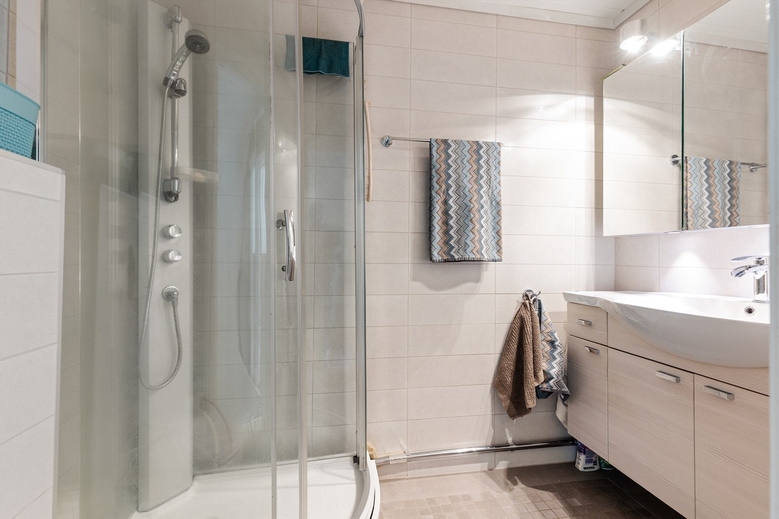 Flislagt bad fra 2011. Badet har varmekabler i gulv, veggmontert toalett og dusjkabinett, samt servantinnredning. Galleribilde