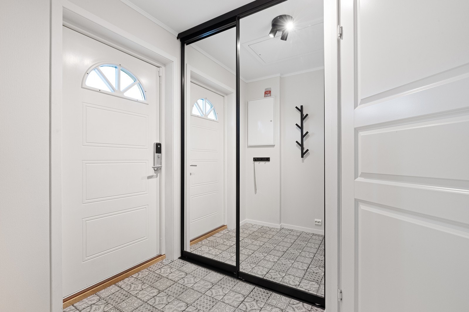 Entréen har flislagt gulv og malte vegger, og inneholder skyvedørsgarderobe for praktisk oppbevaring. Galleribilde