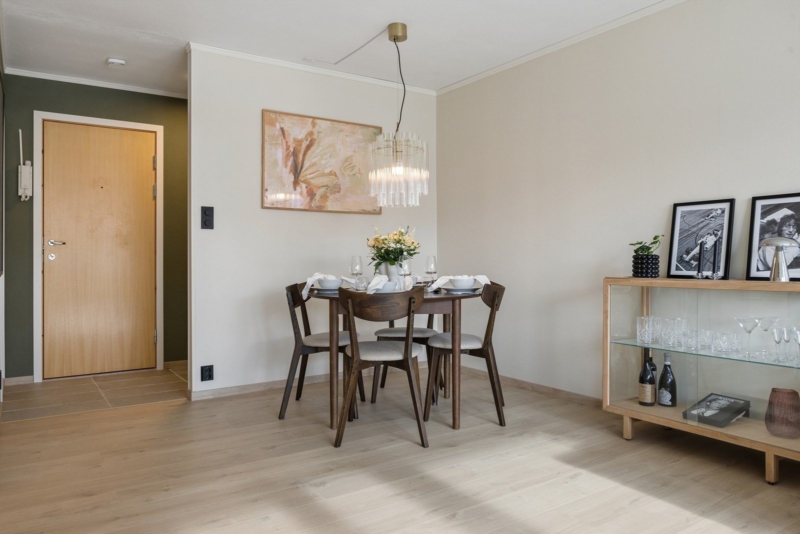 Spiseplassen er naturlig plassert i tilknytning til både kjøkkenet og stuen. En helhetlig og tidsriktig stil binder sammen kjøkken, spisestue og entré. Galleribilde