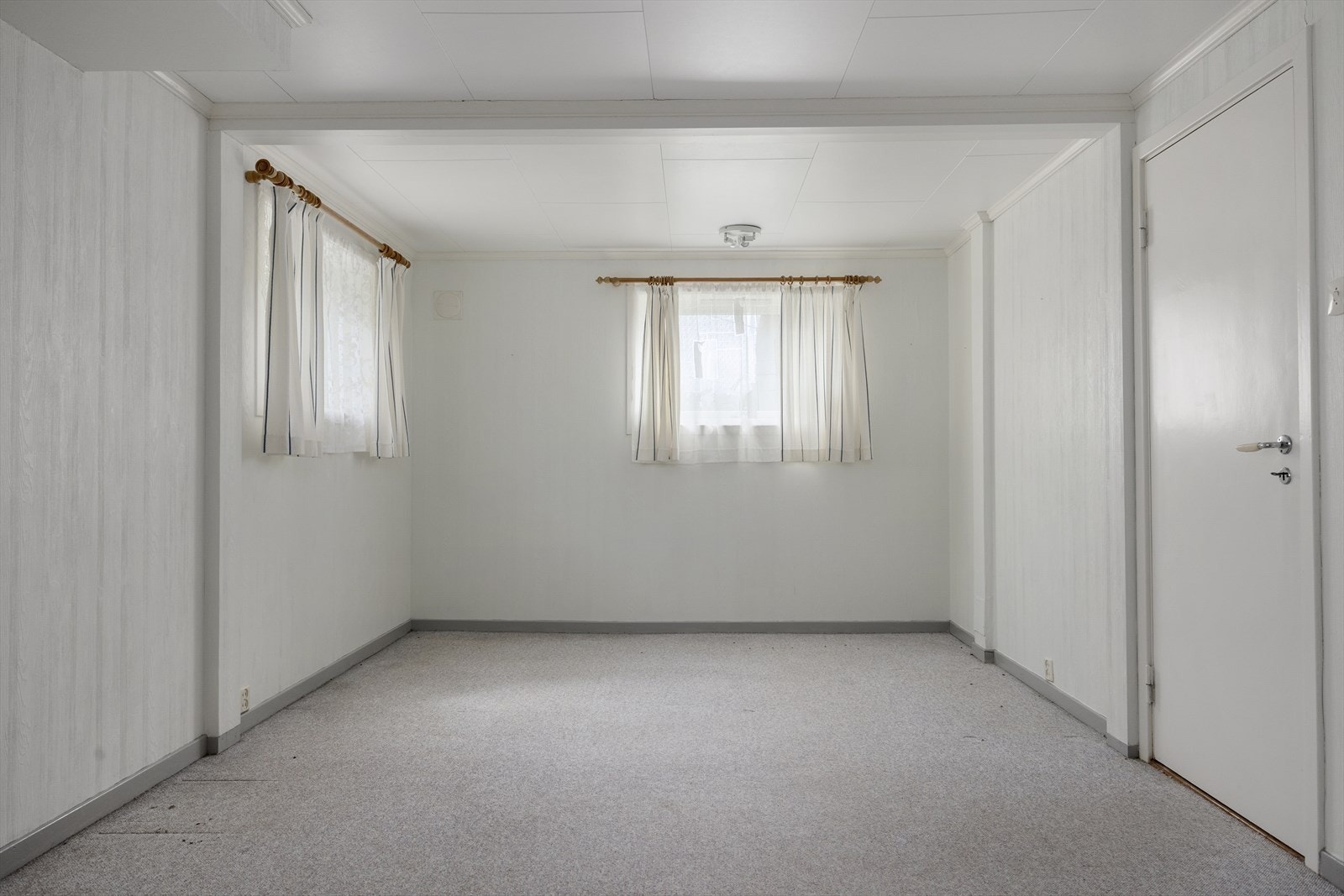 Kjellerstue med teppe på gulvet, som gir en ekstra sone for opphold. Galleribilde