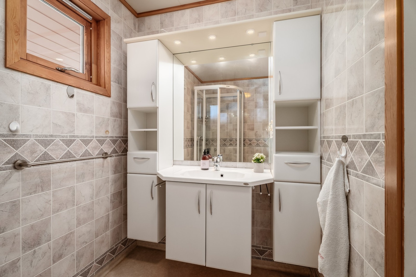 Badet er oppusset cirka rundt år 2000 og har pene baderomsplater på vegg samt fin og praktisk baderomsinnredning. Galleribilde