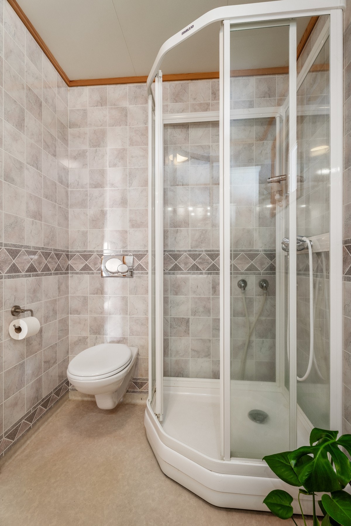 Oppvarming via varmekabler, ellers er badet utstyrt med vegghengt WC, dusjkabinett og med vinylbelegg på gulv. Galleribilde