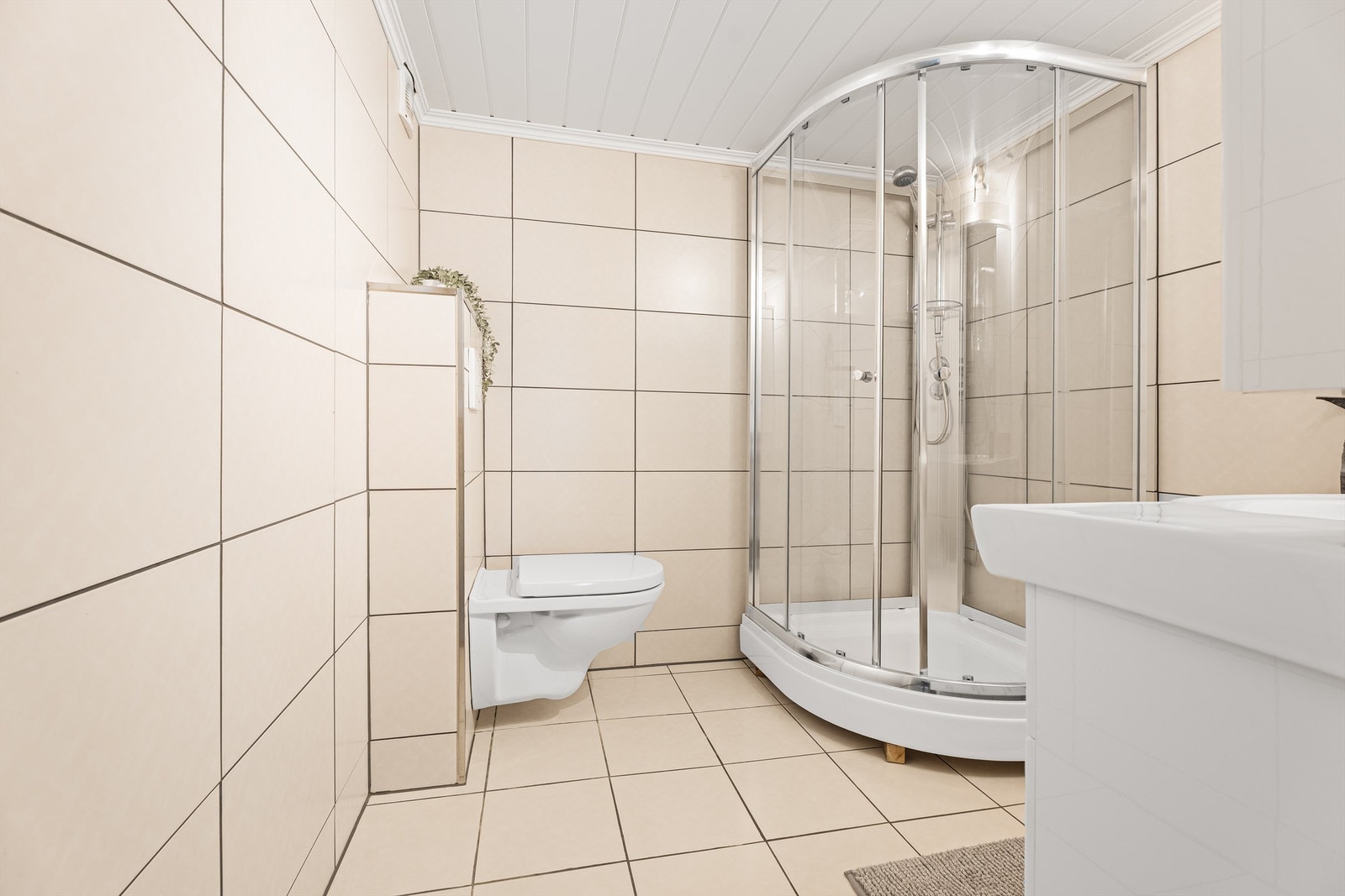 Badet i 1.etg. Innredet med vegghengt wc, servant med skap over og under. Dusjkabinett. Galleribilde