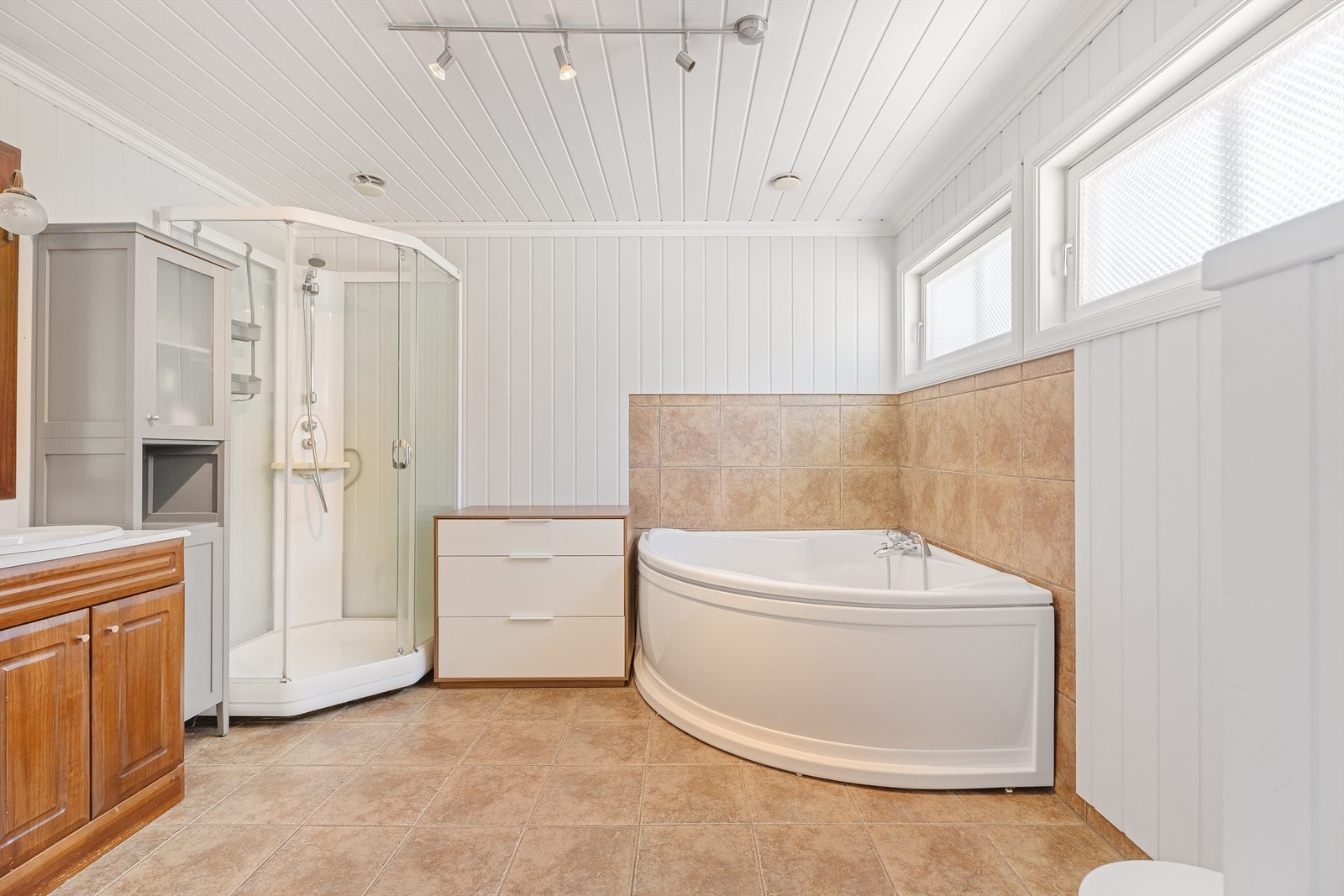 Badet med varmekabler, badekar, dusjkabinett, dobbel servant med skap under. Galleribilde