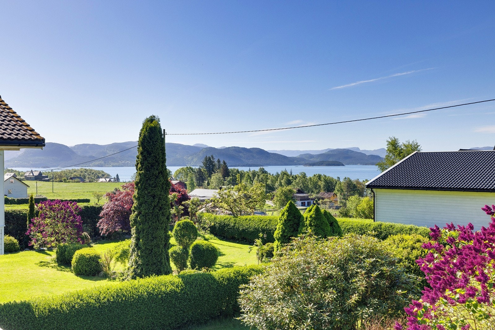 Fra hagen er det utsyn mot fjord og omkringliggende landskap. Galleribilde