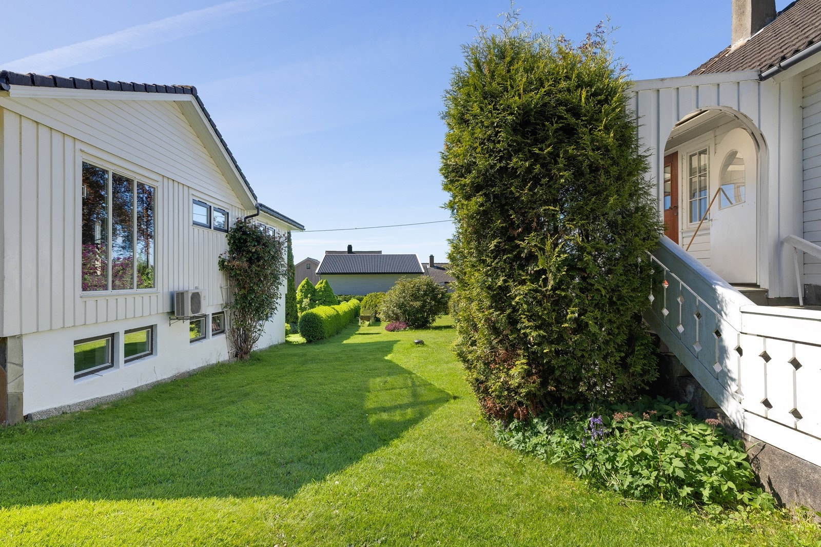 Eiendommen har en stor og velholdt hage med plen og beplantning. Galleribilde