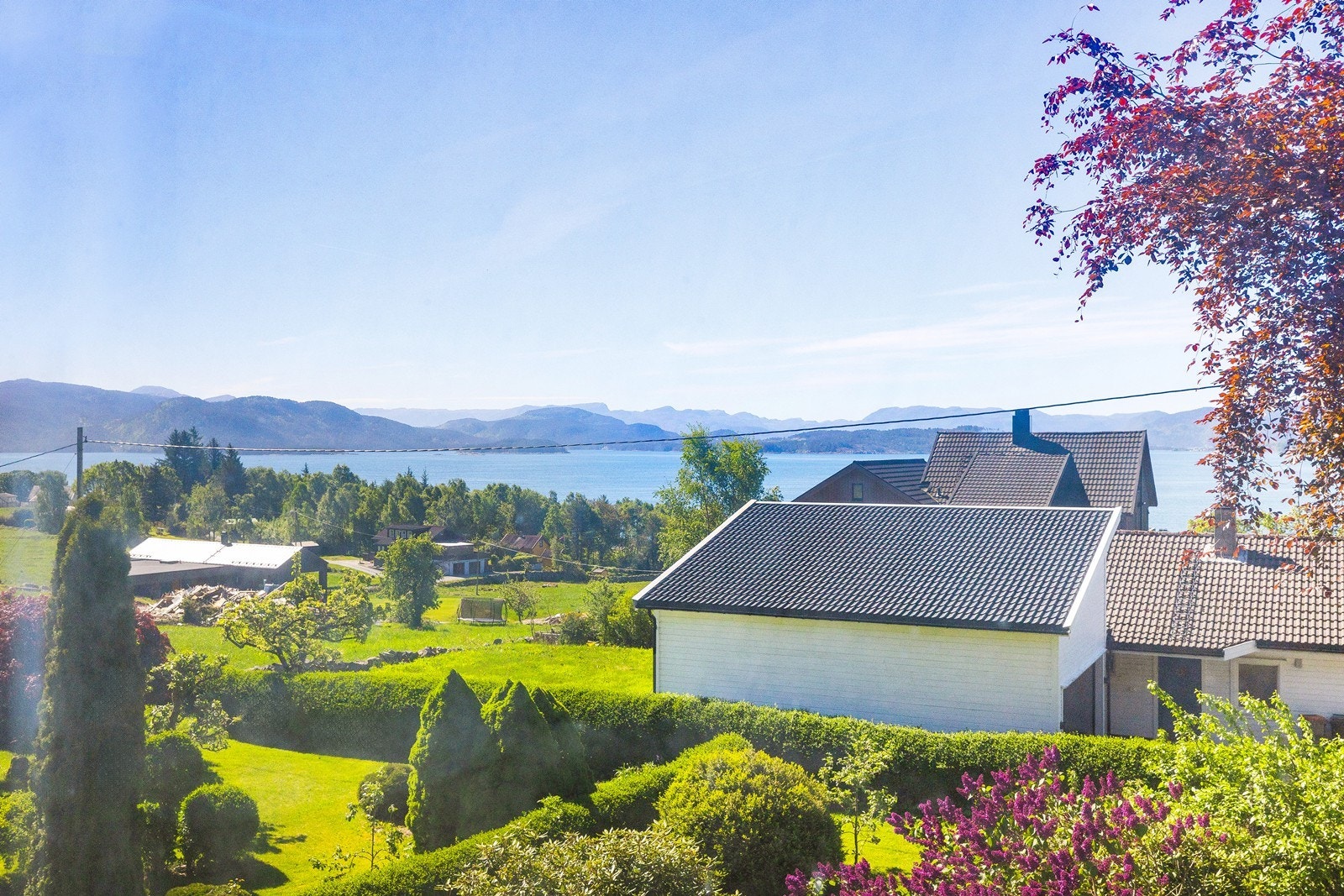 Eiendommen har flott utsikt over nærområdet, grønne omgivelser og fjorden i bakgrunnen. Galleribilde