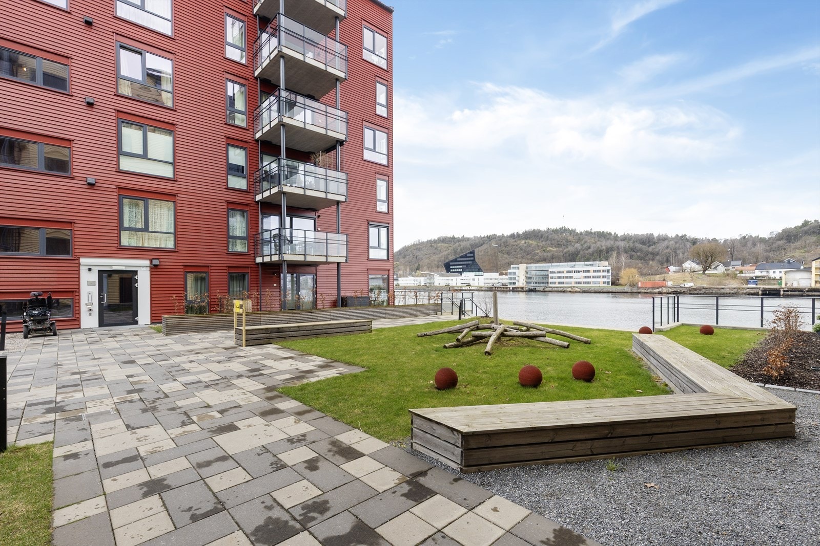 Bred, hellelagt gangsti gjennom tomten og gruslagte områder med mulighet for sykkelparkering. Galleribilde