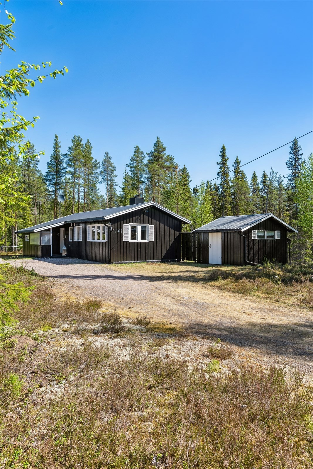 Eiendommen har gruslagt innkjøring og gårdsplass, samt et separat, uisolert uthus for lagring. Galleribilde