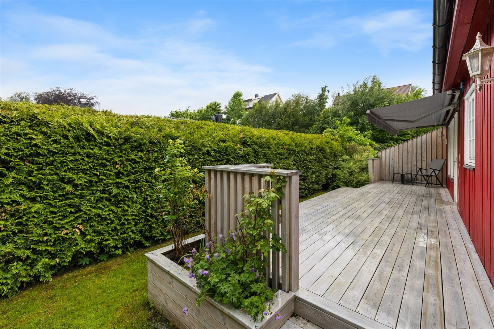 Uteplassen ble betydelig oppgradert i 2022 med en ny, romslig treterrasse på cirka 22 m² og en lettstelt hageflekk med gress og beplantning. Galleribilde