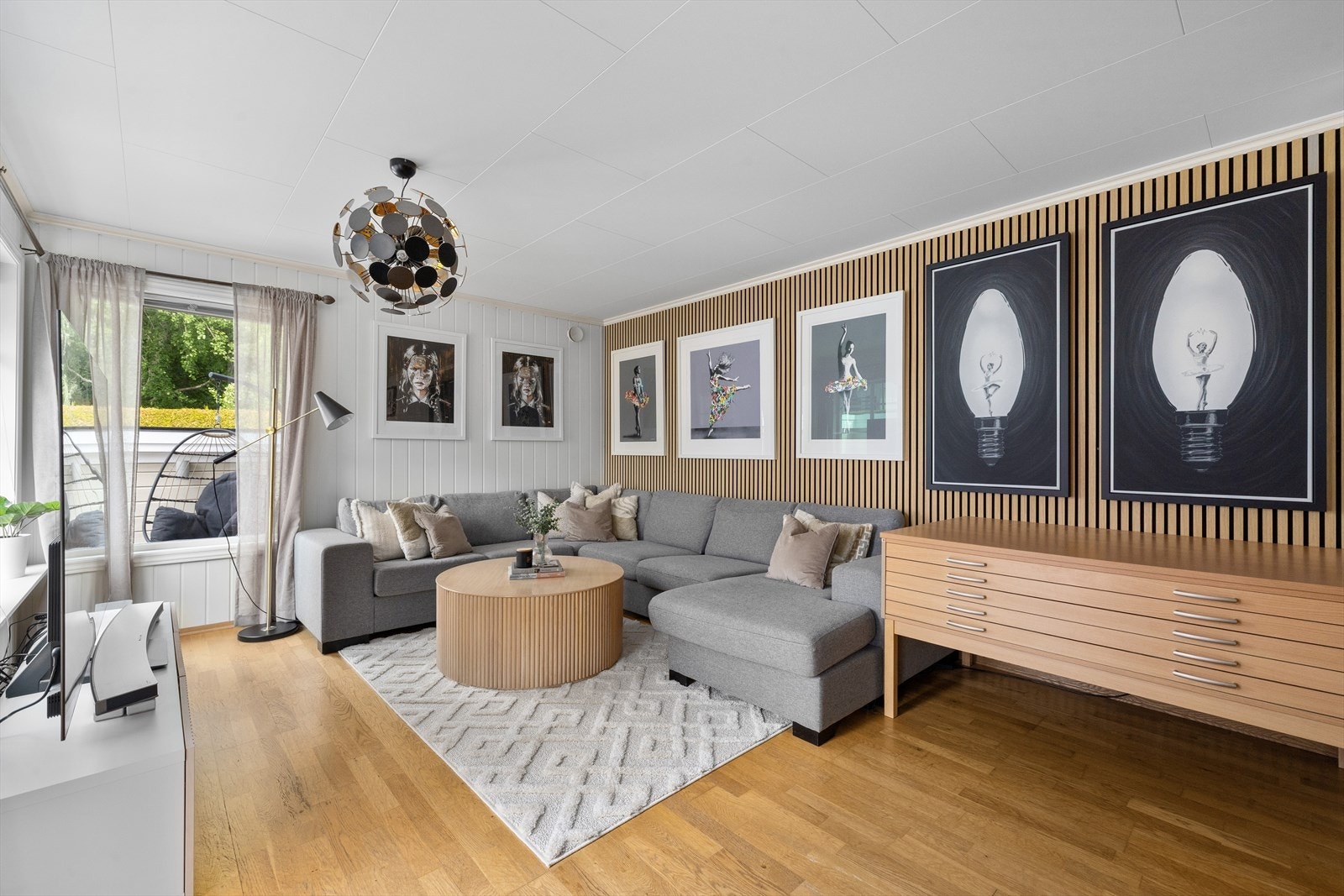 En vegg er kledd med spiler, noe som gir rommet karakter og bryter opp de hvite panelplatene. Galleribilde