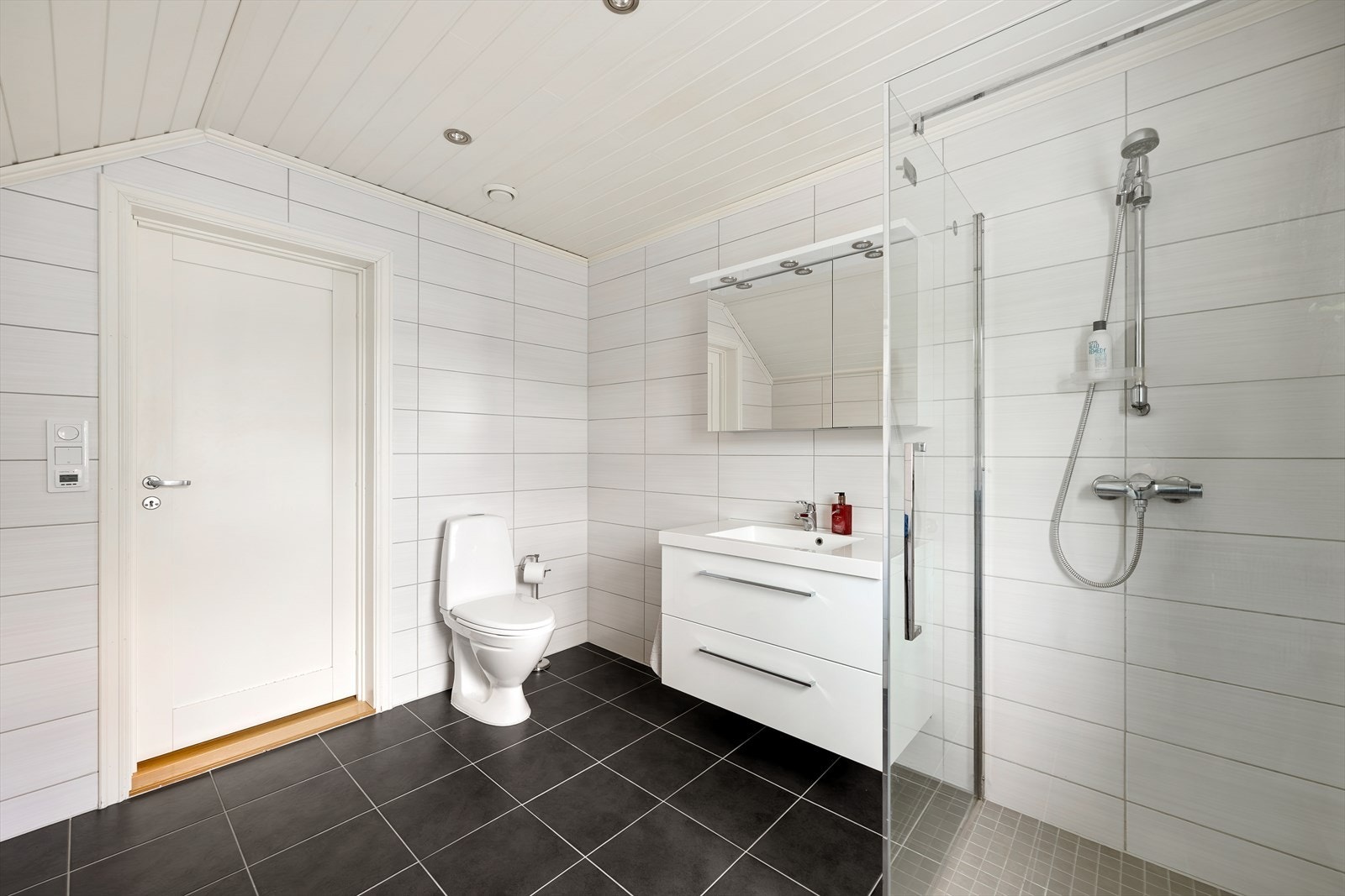 Badet i andre etasje er helfliset og utstyrt med dusjhjørne, toalett og servant med skuffeseksjon. Galleribilde
