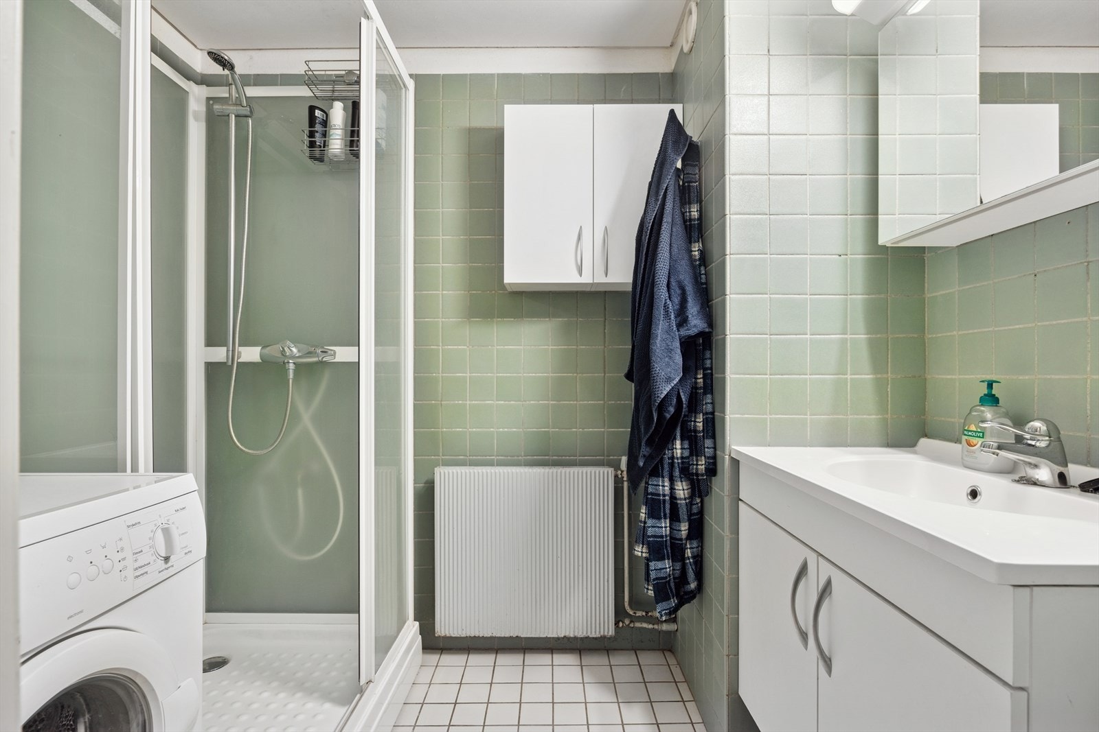Flislagt bad med dusjkabinett og vaskemaskin. Badet er fra 1974 og oppgraderinger må påregnes. Galleribilde