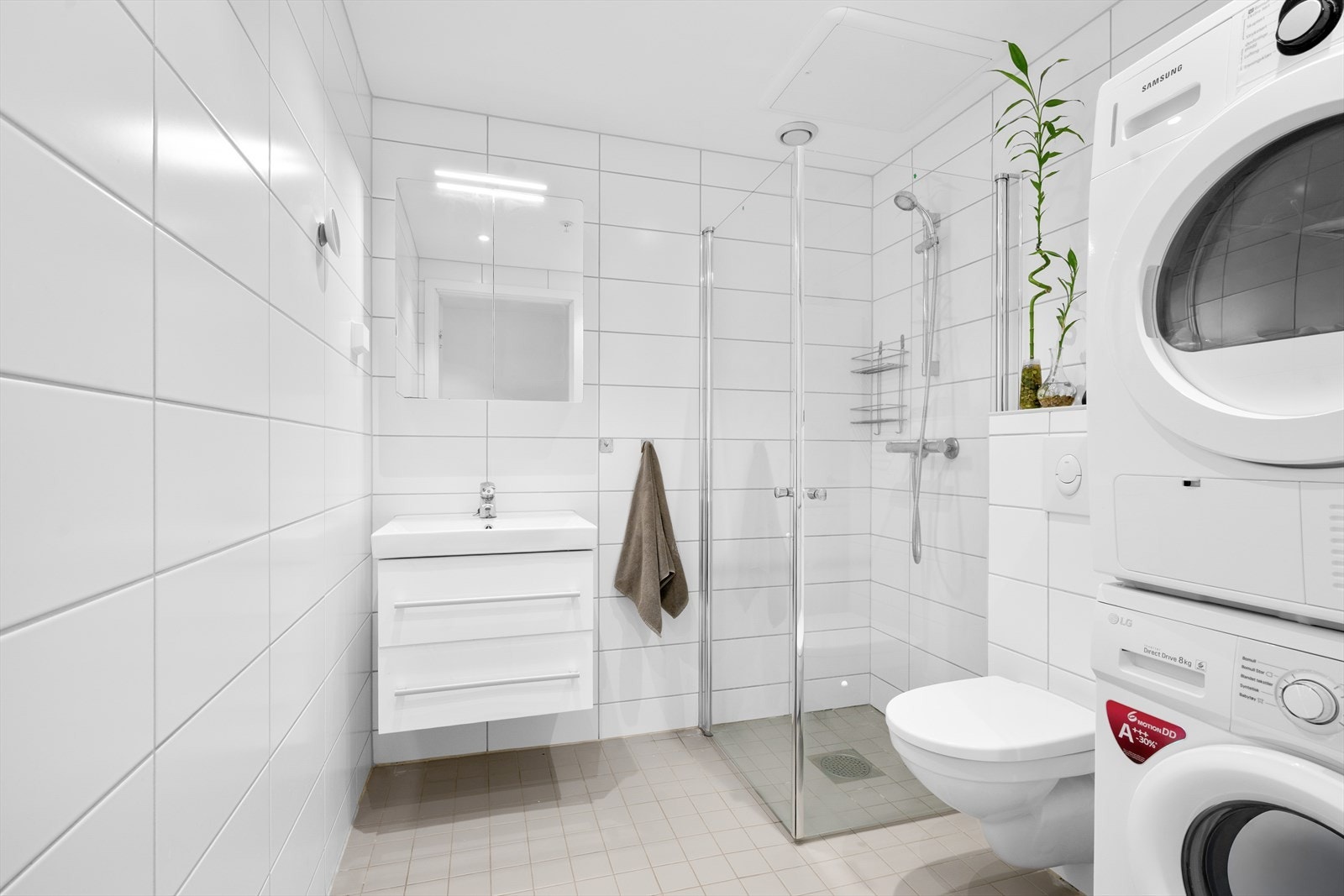 Badet fremstår lyst og moderne med helflisede vegger i lyse toner som gir et rent og tidløst uttrykk. Galleribilde