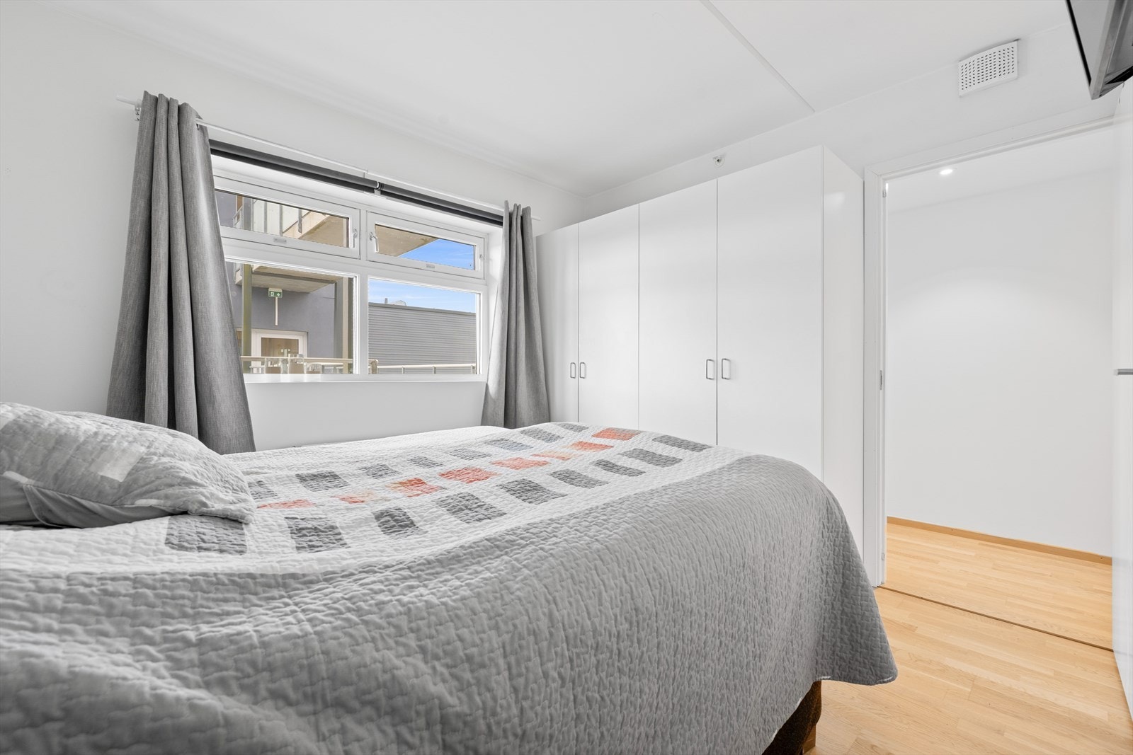 Rommet byr på praktisk garderobeløsning med skap som gir god oppbevaringsplass. Vindusflater slipper inn rikelig med naturlig lys og bidrar til et luftig preg Galleribilde