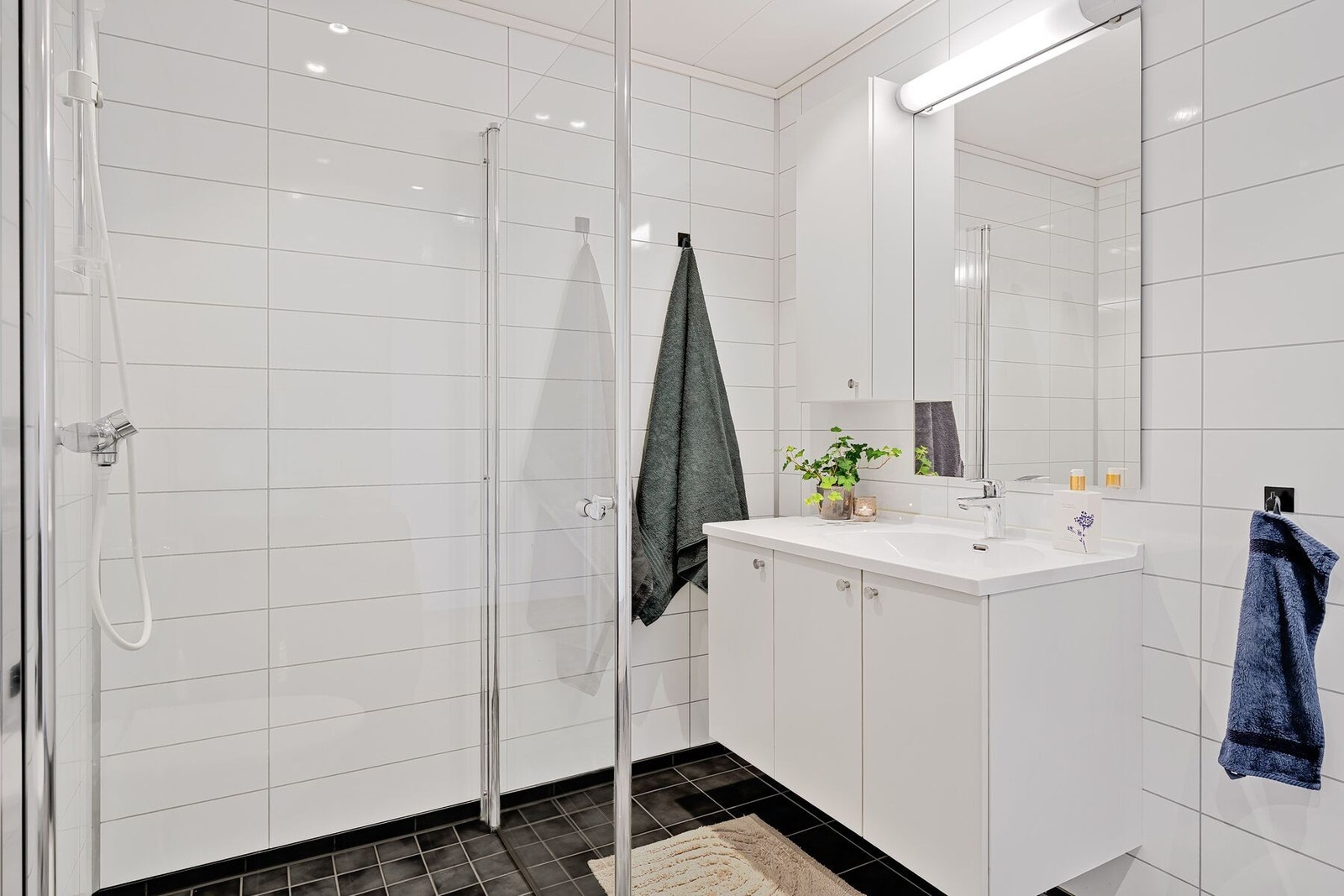 Badet er utstyrt med baderomsinnredning, dusjplass, toalett og opplegg for vaskemaskin Galleribilde