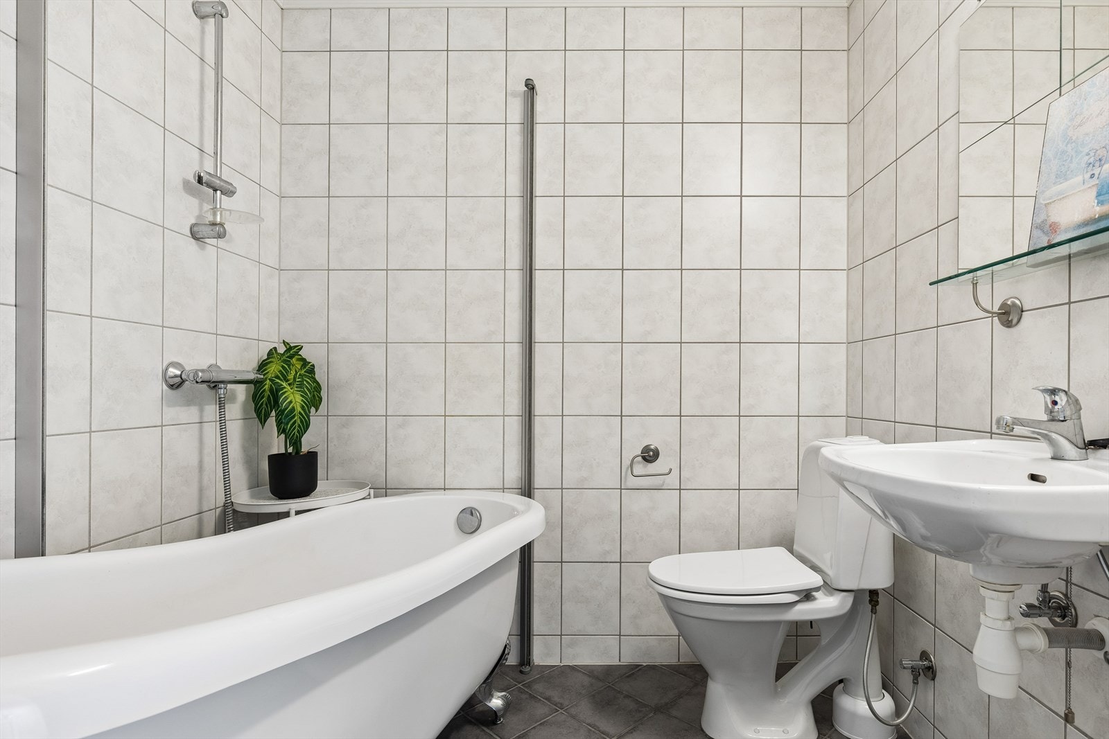 Badet i andre etasje har flislagt gulv med varme og frittstående badekar. Galleribilde