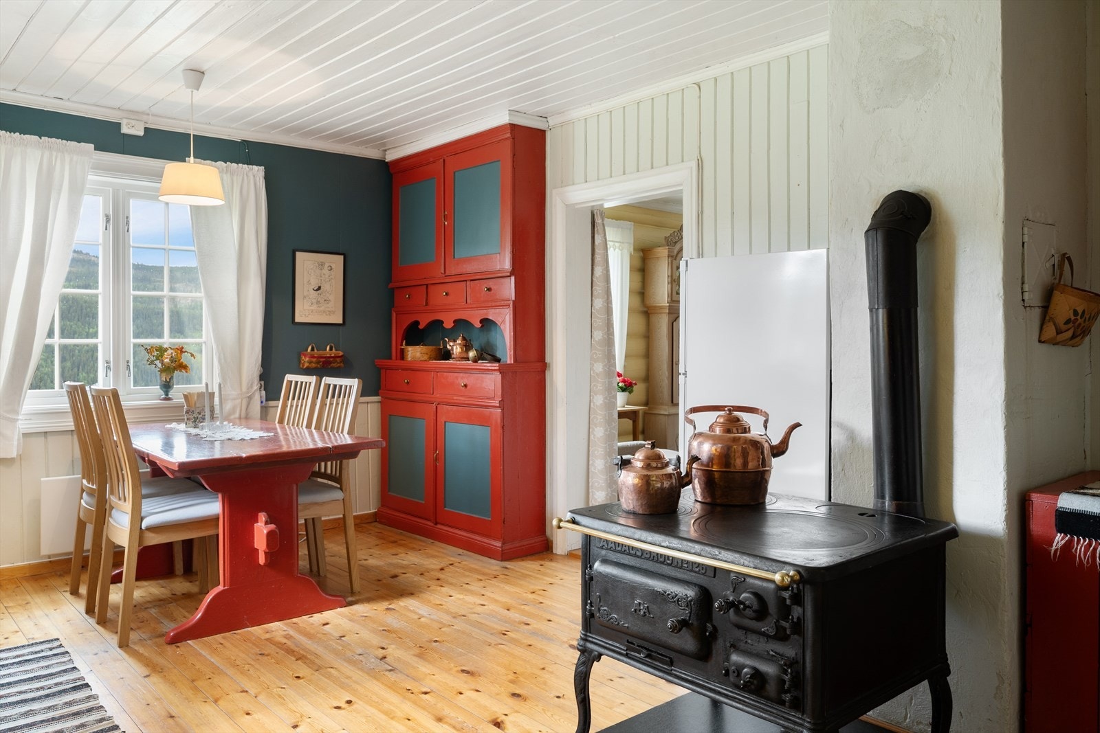 En klassisk vedkomfyr supplerer oppvarmingen og bidrar til den tradisjonelle stilen. Galleribilde