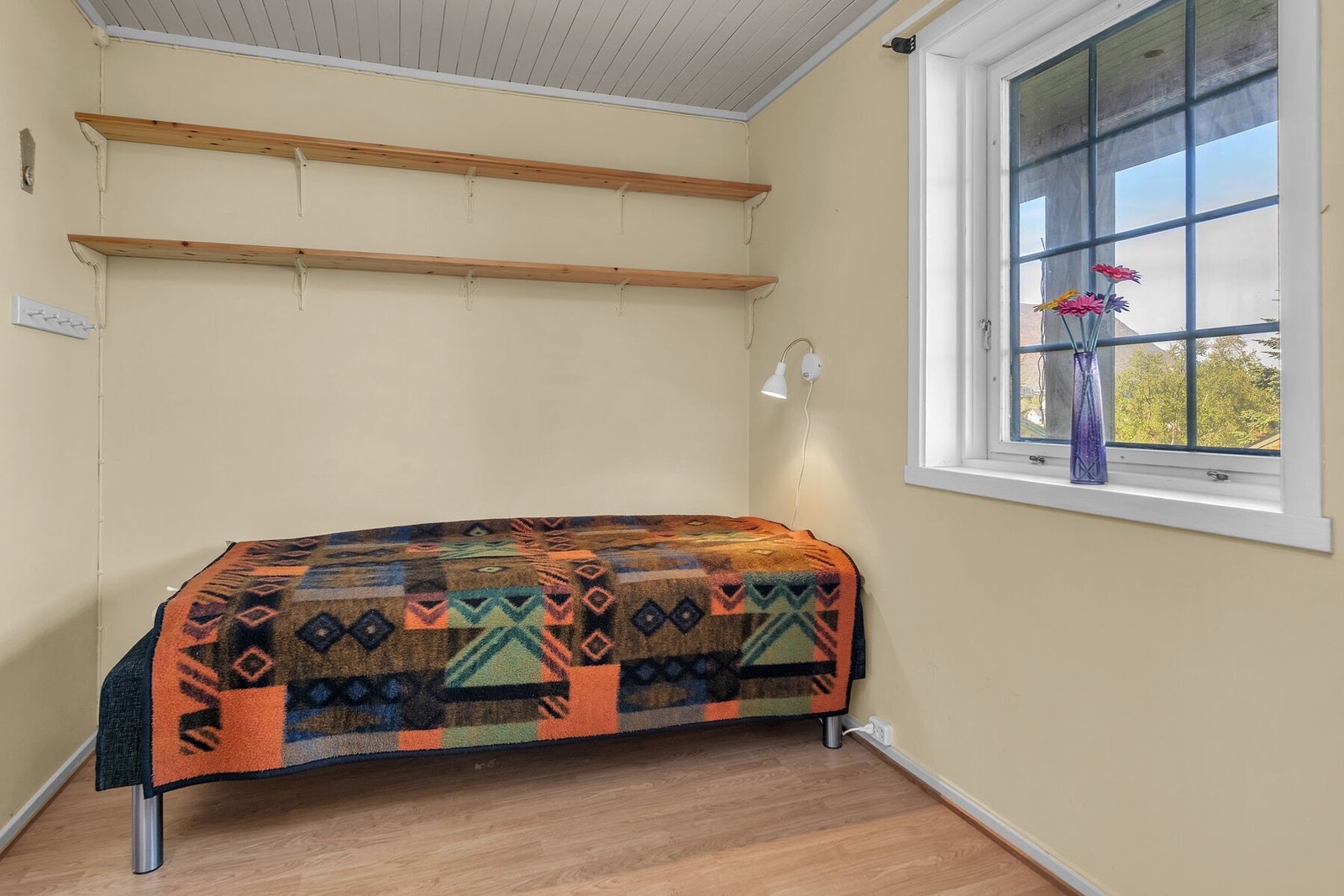 Soverom med laminat på gulv og panel på vegger. Galleribilde