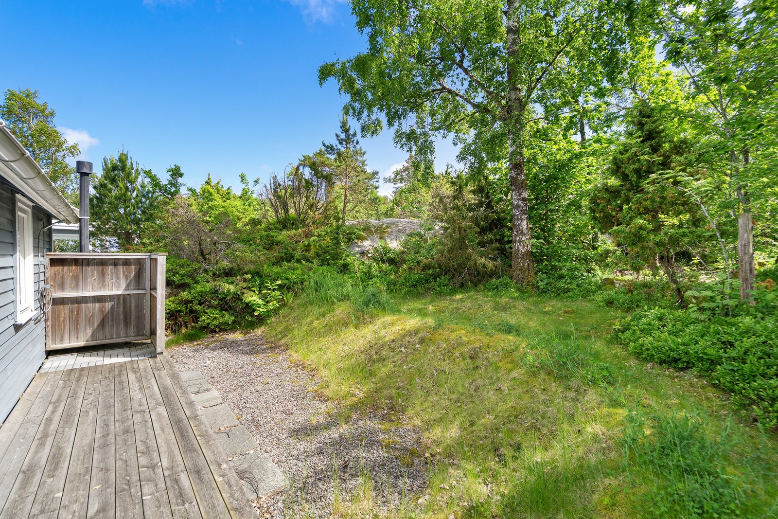 Bak annekset er det etablert en hyggelig utedusj skjermet mot grønne arealer - perfekt etter en dag på sjøen eller stranden. Galleribilde