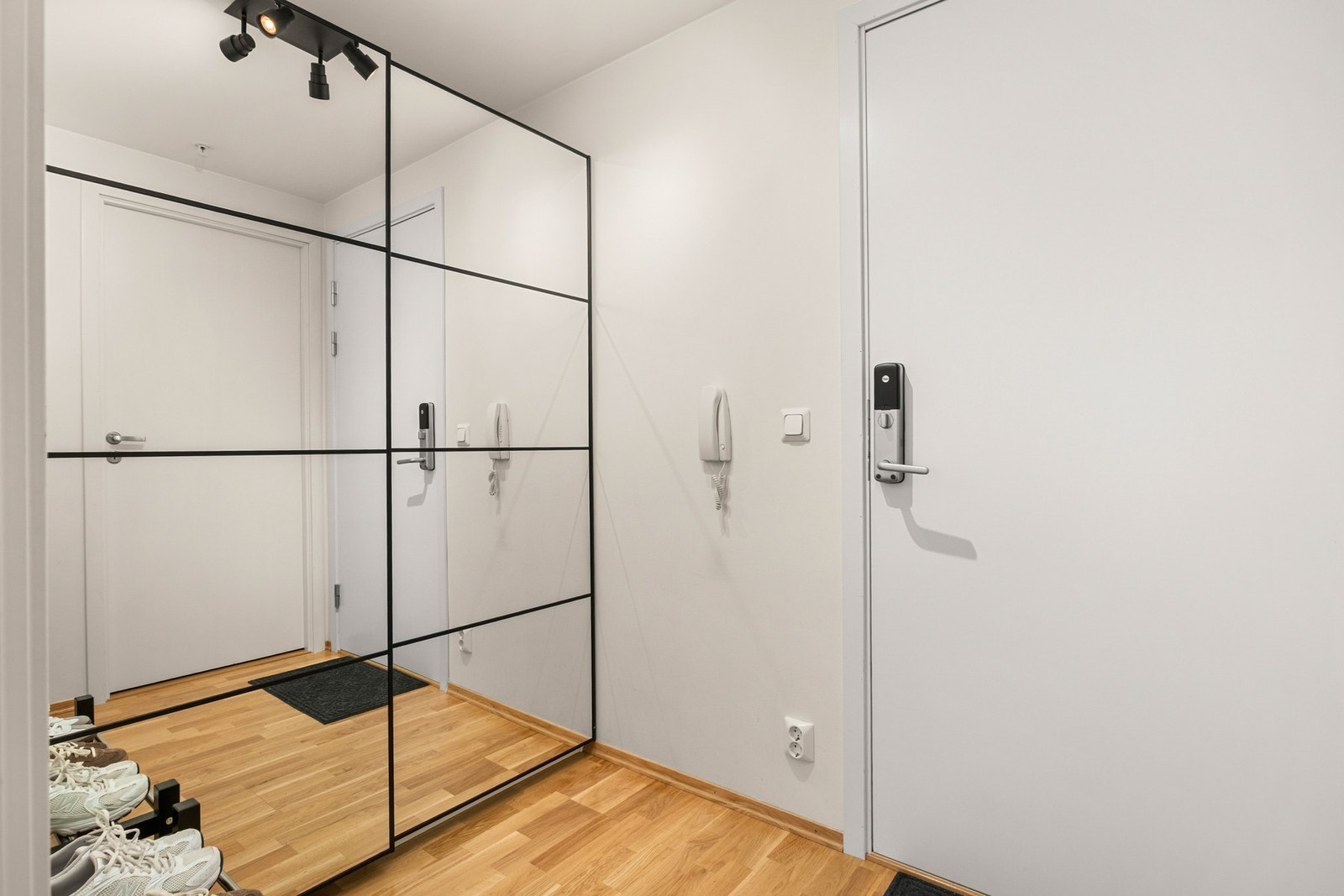 Romslig og innbydende entrè med god plass til en stor skivedørsgarderobe for oppbevaring av sko og yttertøy. Det er montert kodelås på døren. Galleribilde