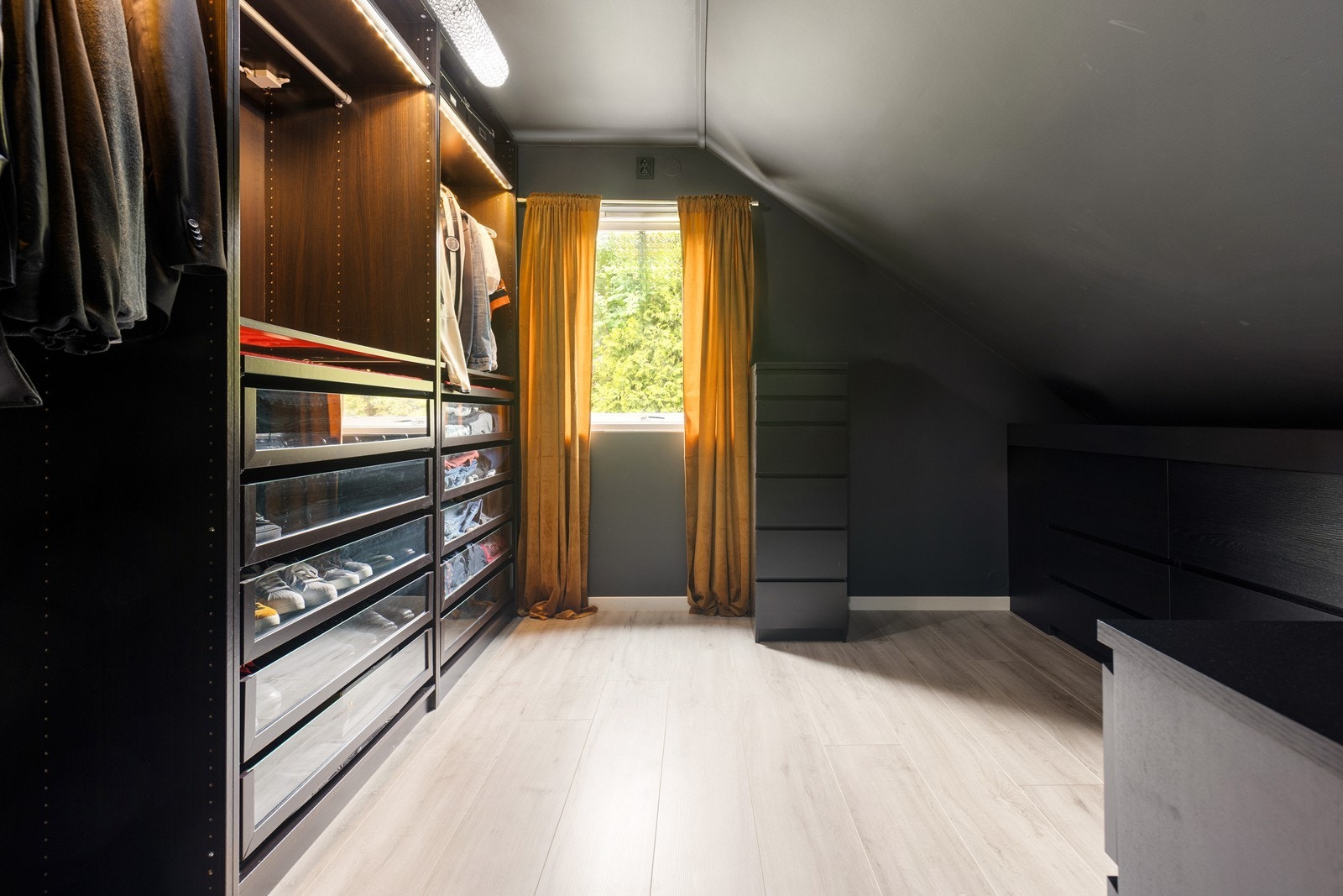 Et av soverommene er i dag innredet som et romslig walk-in-closet med systeminnredning. Galleribilde