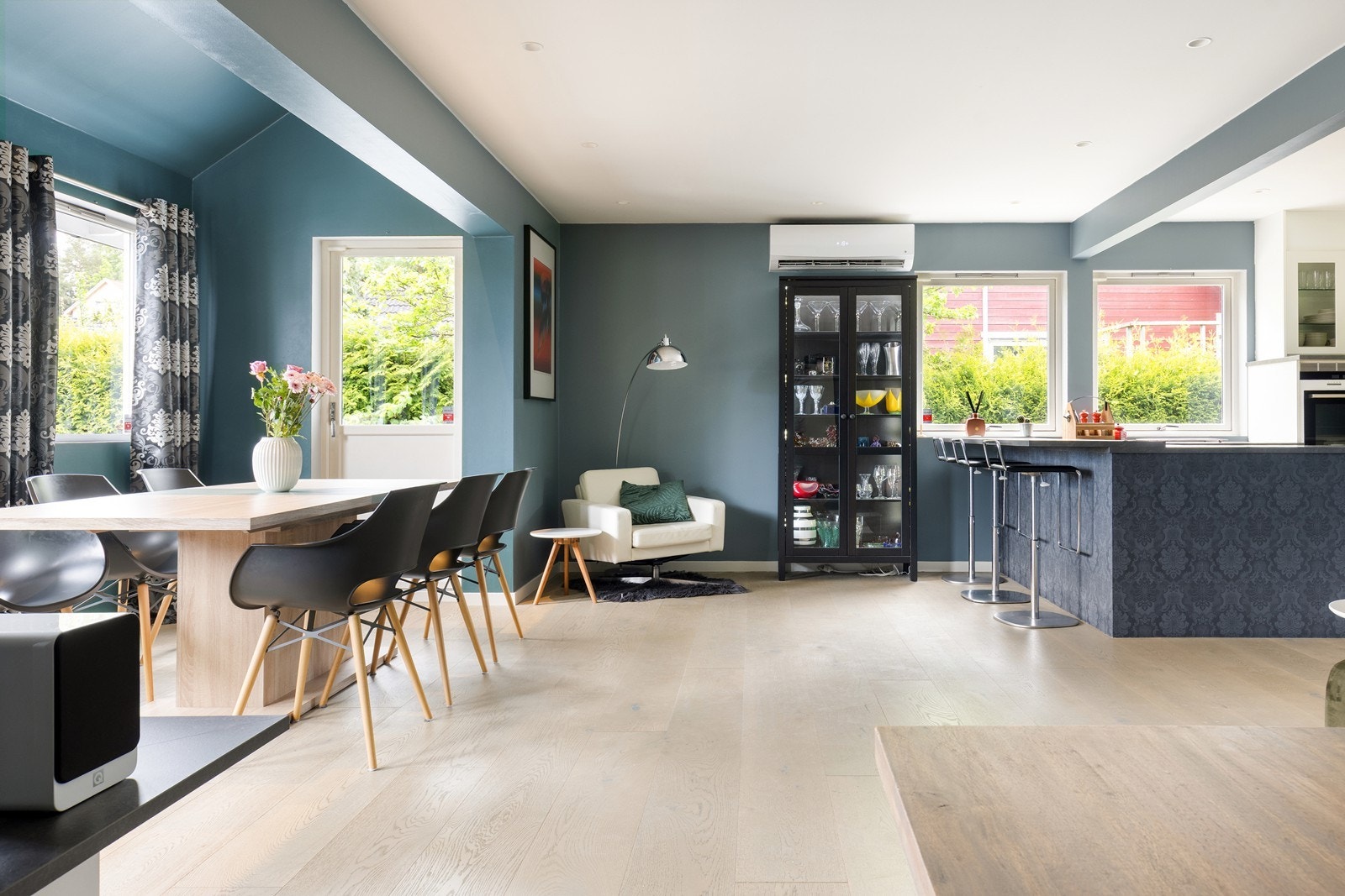 Den åpne løsningen mellom stue og kjøkken skaper et sosialt og luftig allrom, perfekt for familieliv og sammenkomster. Galleribilde