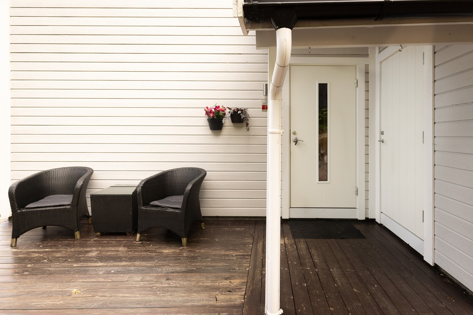 Overbygd inngangsparti med plass til en liten sittegruppe. Galleribilde
