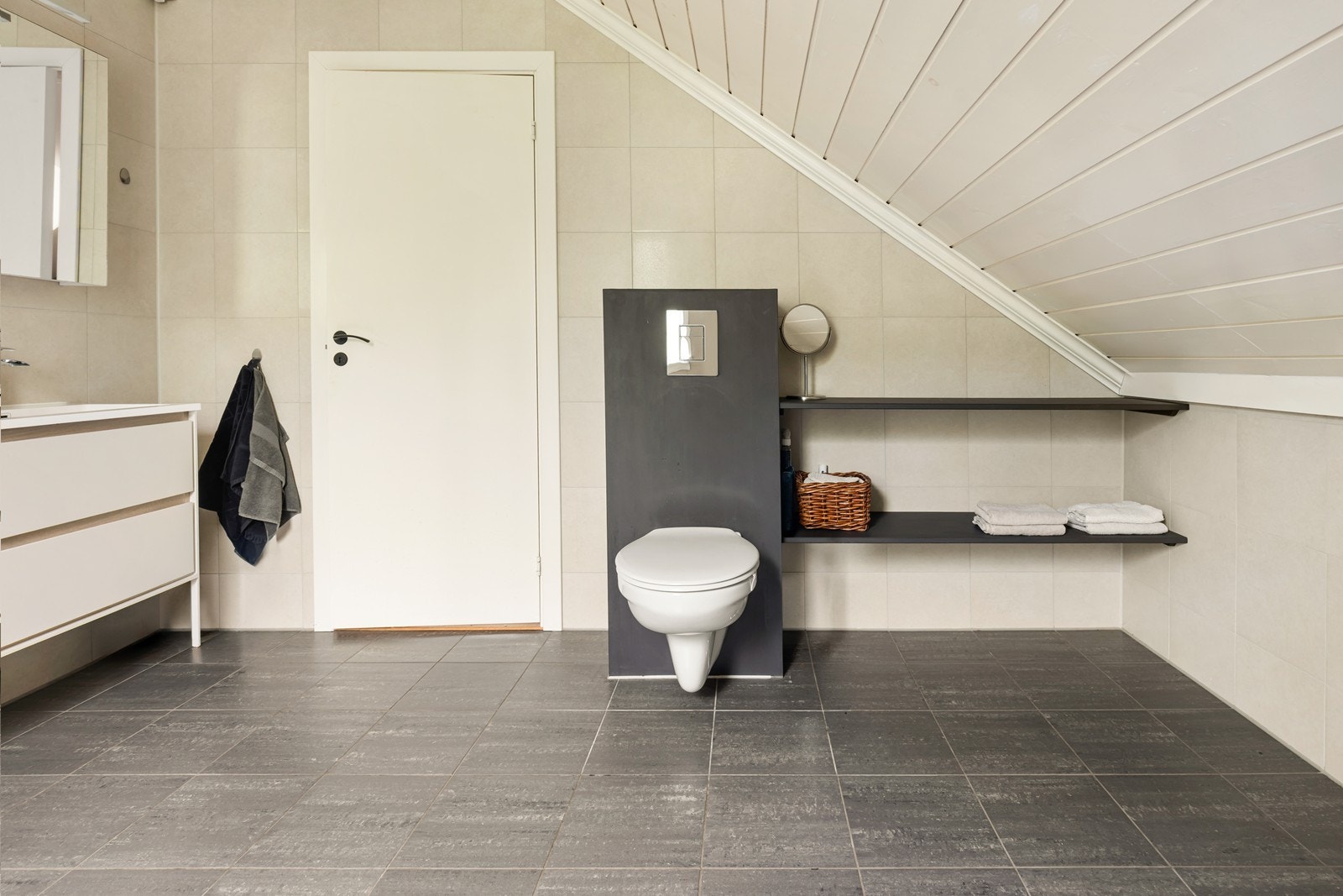 Badet har vegghengt toalett og praktiske, innebygde hyller for oppbevaring. Galleribilde