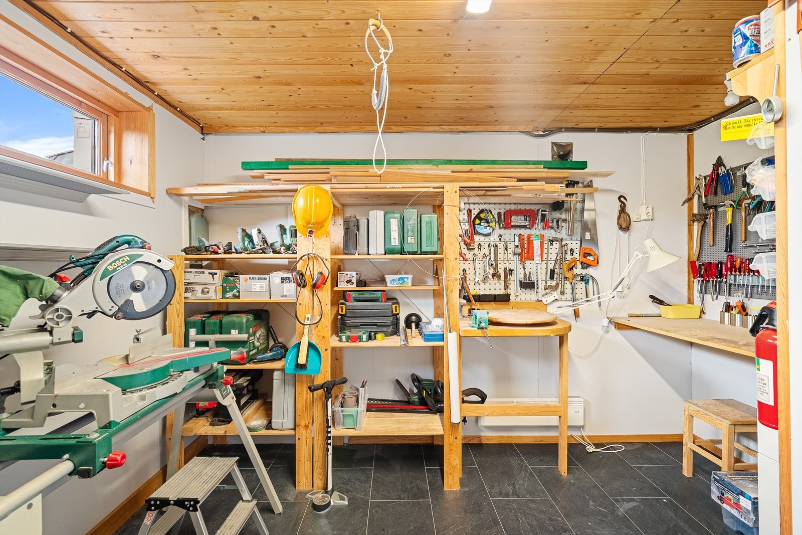 Velutstyrt verksted med benk og oppbevaringsløsninger - perfekt for den praktiske. Galleribilde