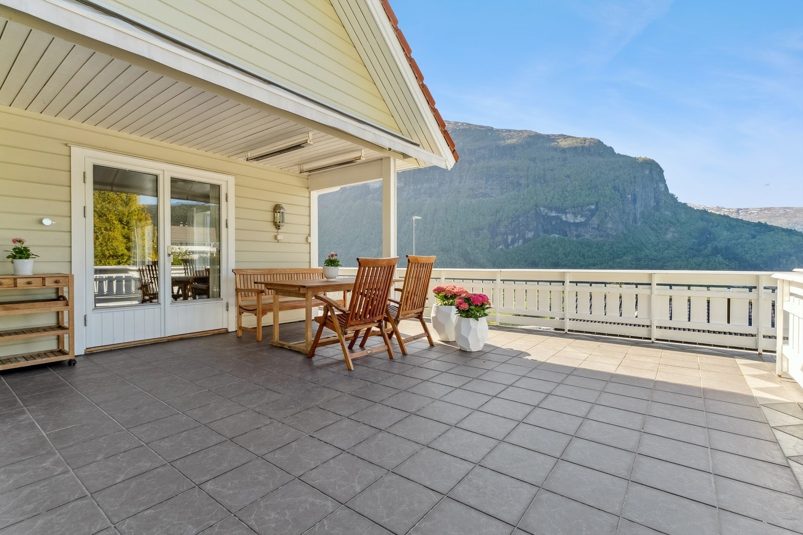 Den sør- og vestvende terrassen på 61 m² er delvis overbygd og har god plass til fleire sitjegrupper. Galleribilde