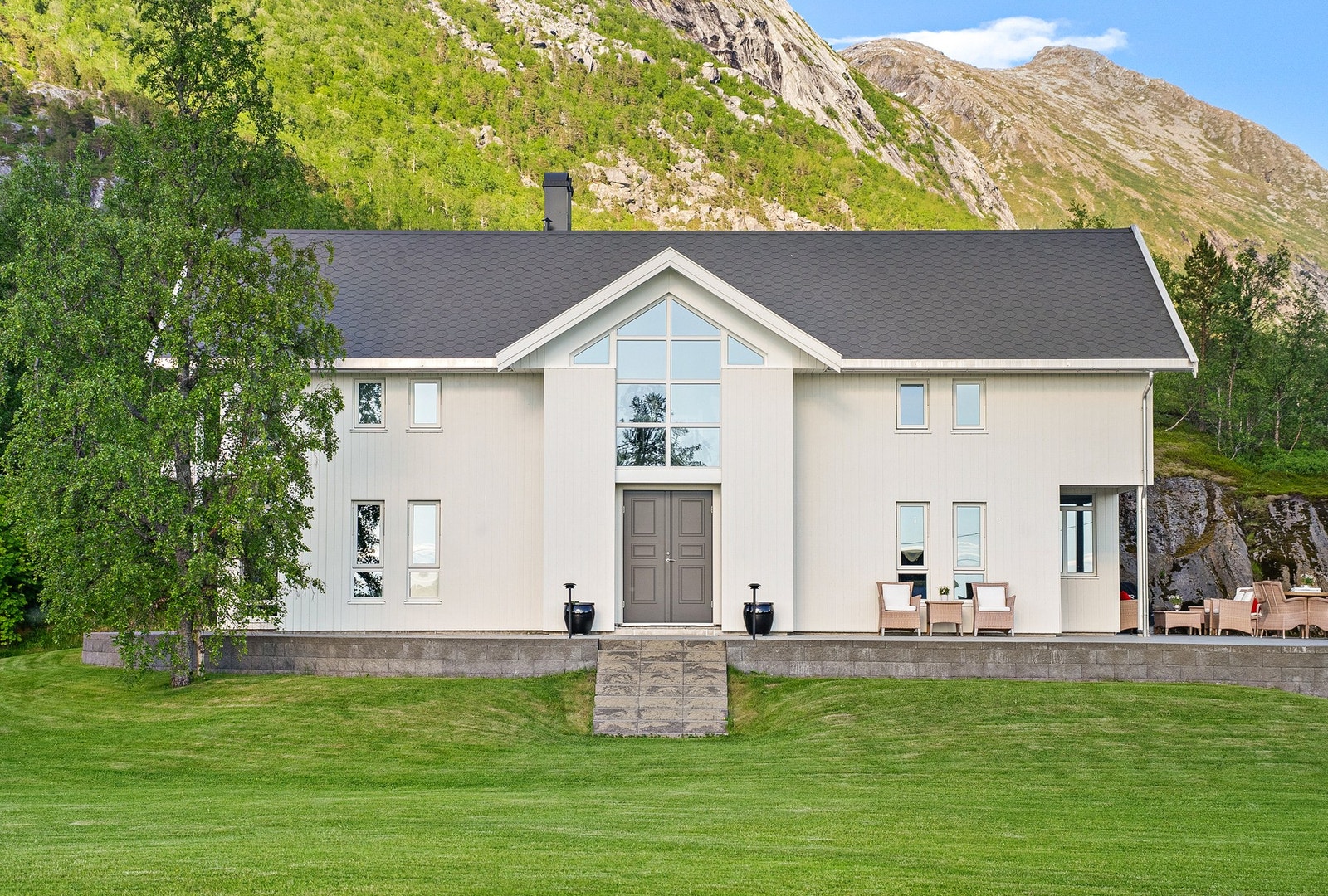 Boligen har en fantastisk fasade, med monterte lys som lyser opp huset på kveldstid Galleribilde