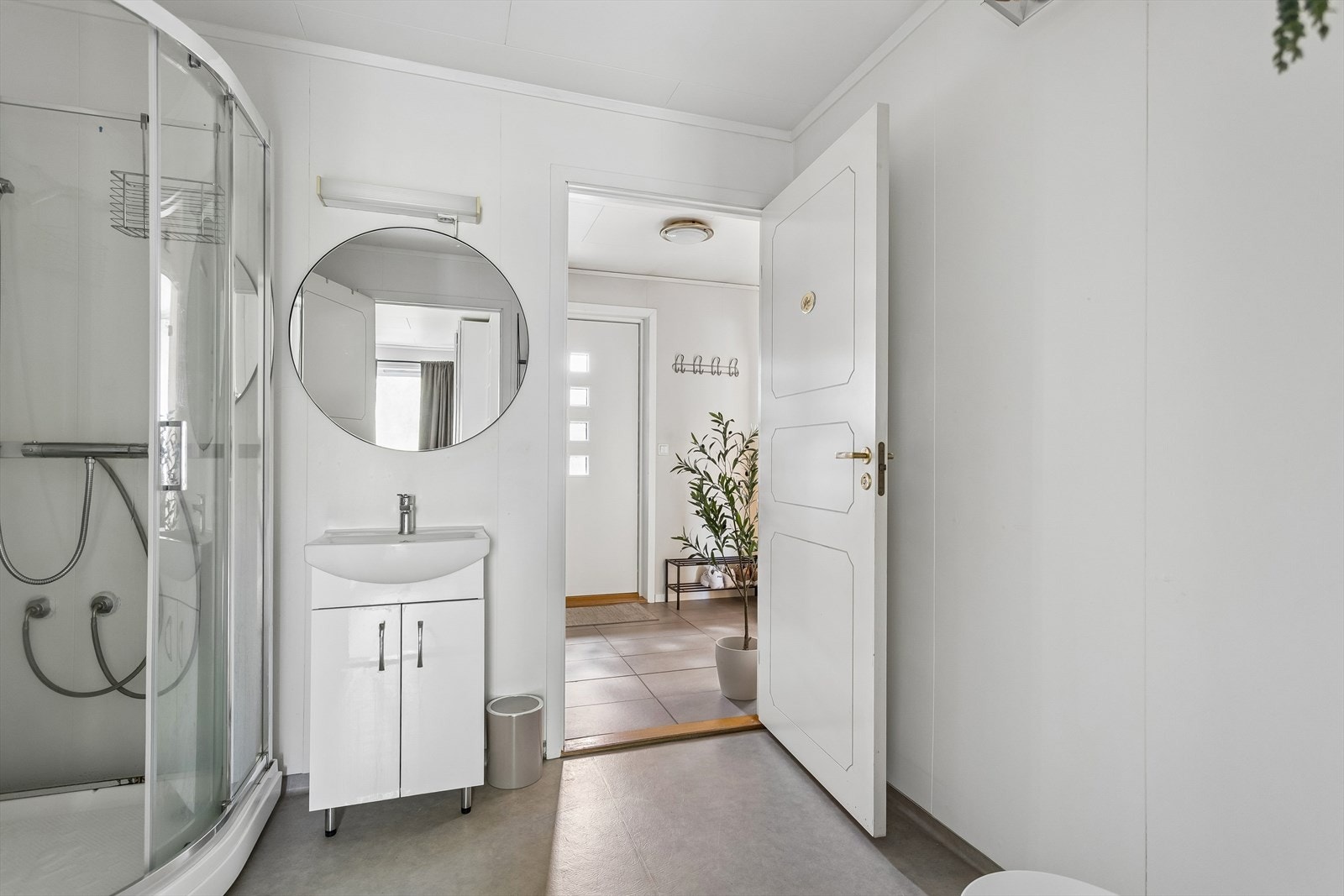 Badet har gulvstående toalett, servant i innredning og dusjkabinett. Galleribilde