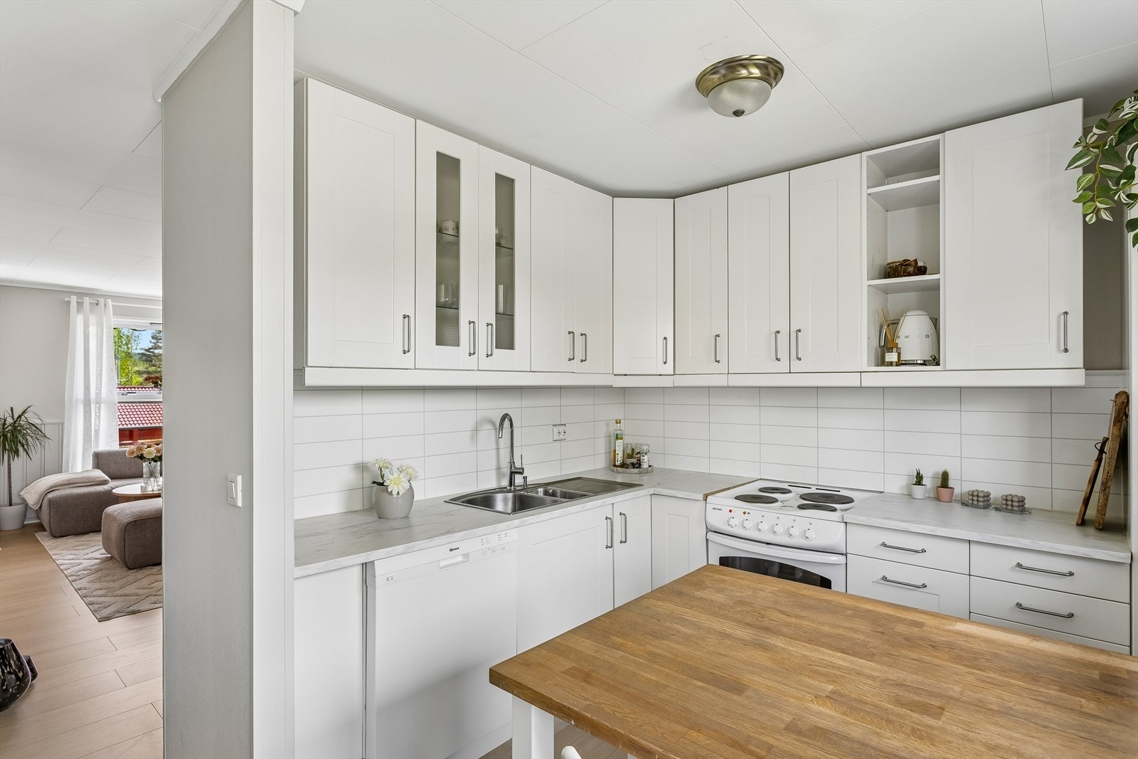 Kjøkkeninnredning med takhøye overskap, laminat benkeplate og kitchen wall mellom benk og overskap. Galleribilde