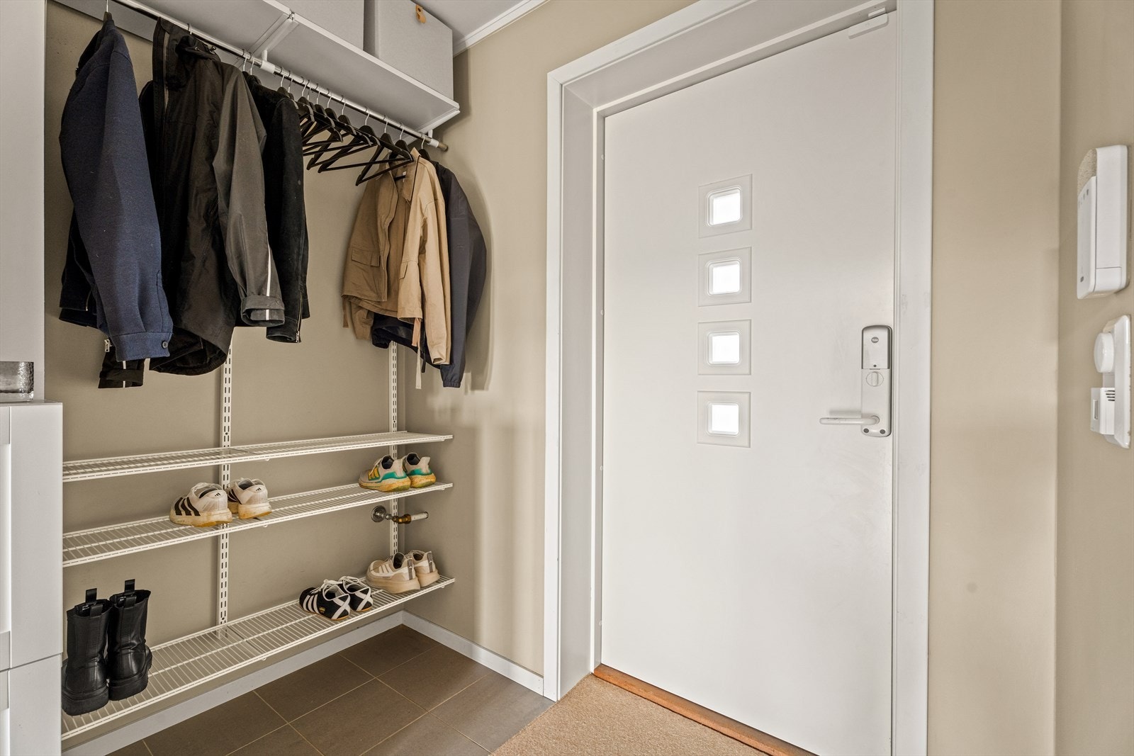 Entréen har malt inngangsdør med glassfelt og en smart garderobeløsning. Galleribilde