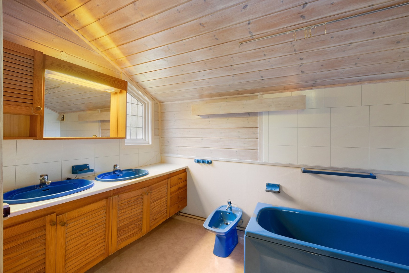 Badet har vinylbelegg på gulv og våtromstapet, plater og trepanel på vegg. Galleribilde