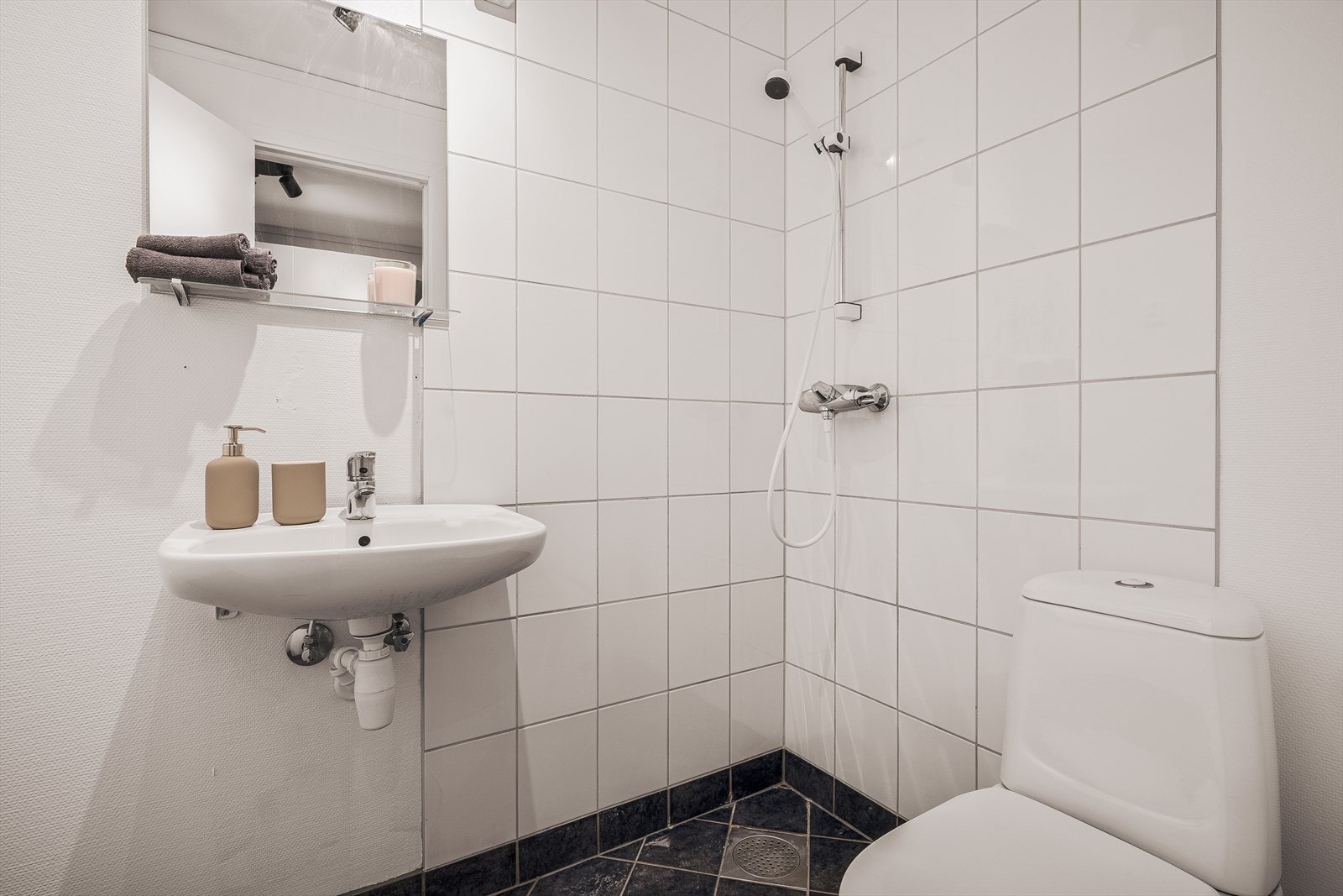 Badet i hoveddelen har keramiske fliser på gulv og vegger i dusjsonen. Galleribilde