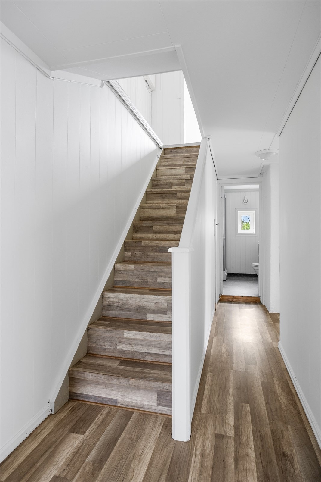 Fra hallen i første etasje fører en malt rettløpstrapp opp til andre etasje. Galleribilde