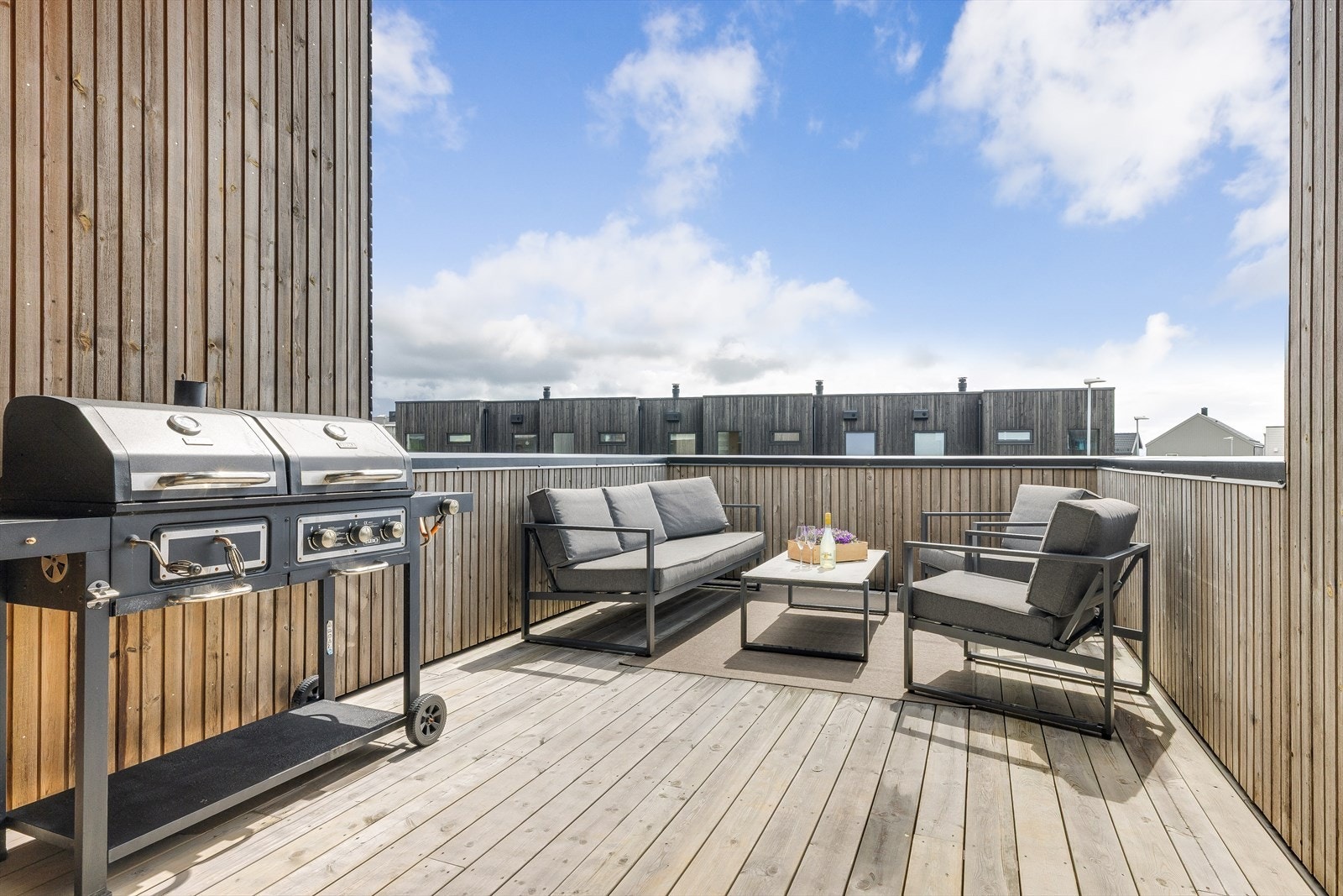 En skjermet og sørvendt terrasse som fungerer som en forlengelse av stuen på sommerstid. Galleribilde