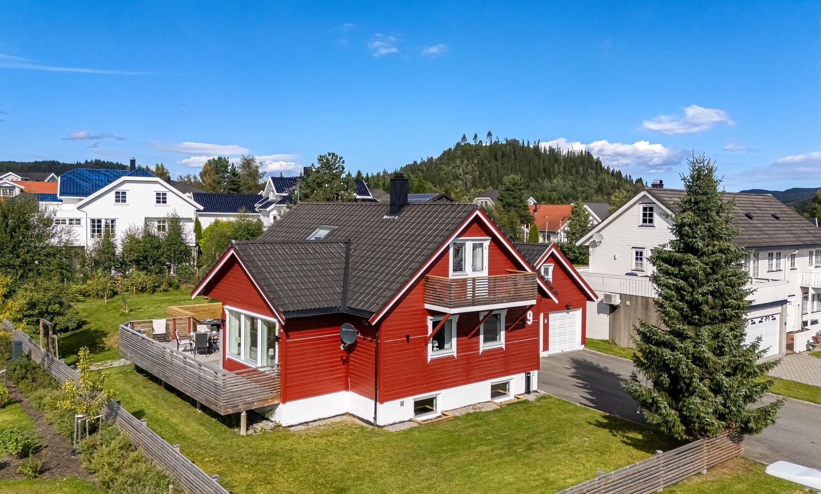Asfaltert gårdsplass og dobbelgarasje med bod i bakkant Galleribilde