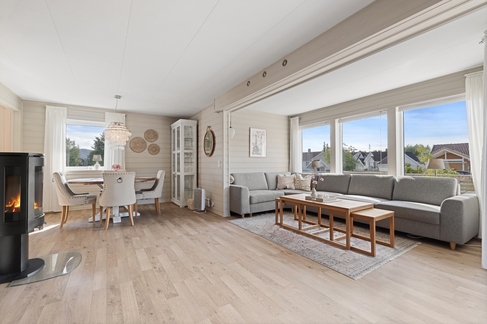 Velkommen inn til en romslig og innbydende stue med store vindusflater Galleribilde