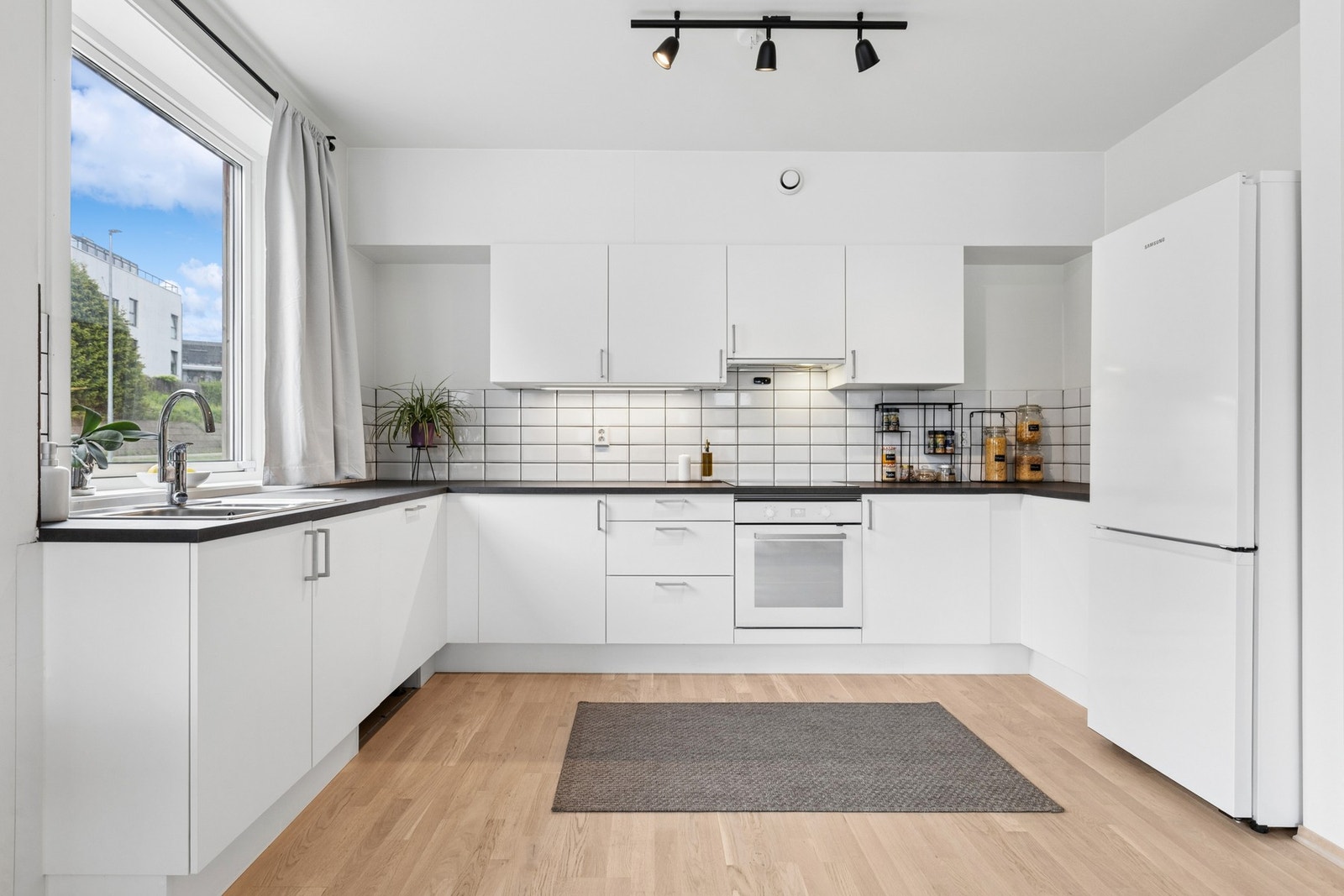 Stilrent kjøkken med gode arbeidsflater og skappplass. Galleribilde