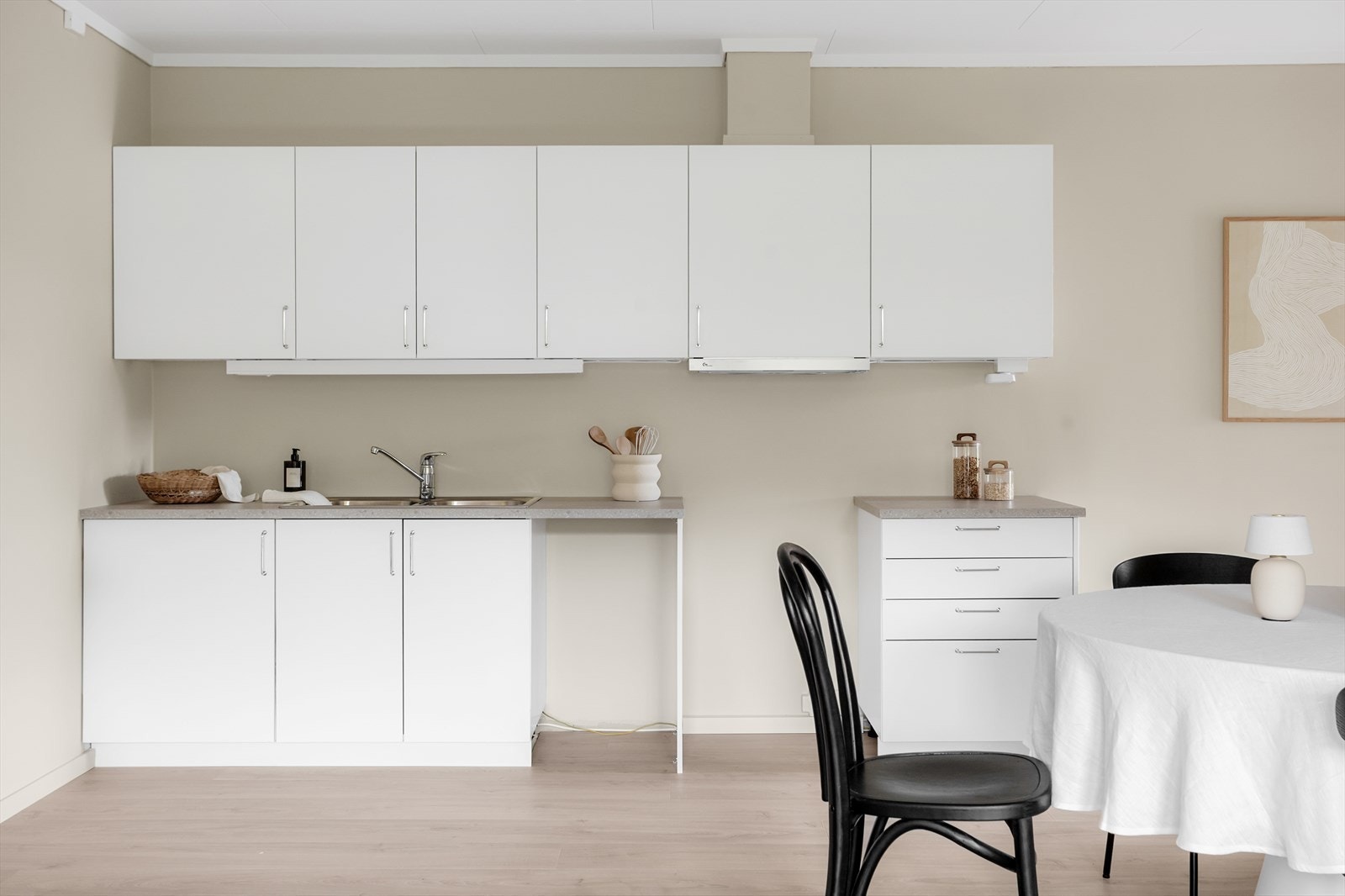 Kjøkkeninnredning med slette fronter og laminatbenkeplate. Varmtvannsberederen er plassert i benkeskap. Galleribilde