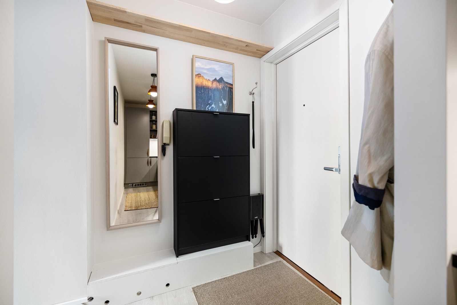 Velkommen inn! Selger har fått etablert en praktisk entré med hylle for oppbevaring, skoskap og nisje for elektrisk utstyrt Galleribilde