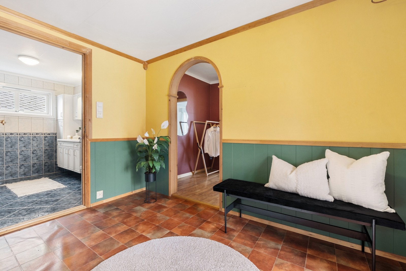 Fra entreen er det inngang til badet og en bueåpning som leder videre inn i boligen. Galleribilde