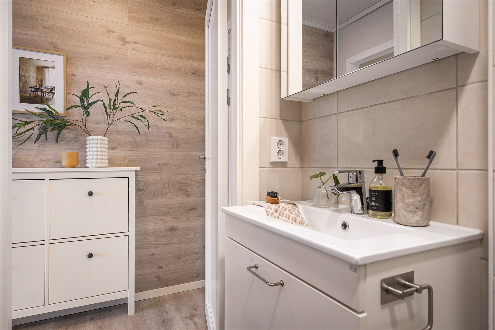 Badet fremstår innbydende og har blitt innredet med wc, servant med møblement, speil, belysning og dusjhjørne. Det er varmekabler i gulv. Galleribilde