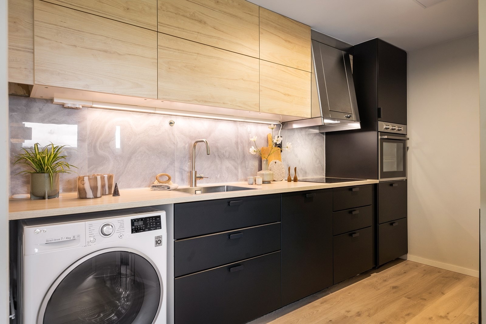 Flott Ikea kjøkken med moderne design, glatte fronter, belysning under overskap og en slitesterk laminert benkeplate. Galleribilde