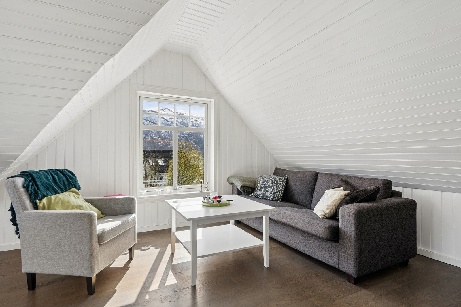 Loftstuen har en lun atmosfære med malt trepanel og plass til en hyggelig sittegruppe. Galleribilde