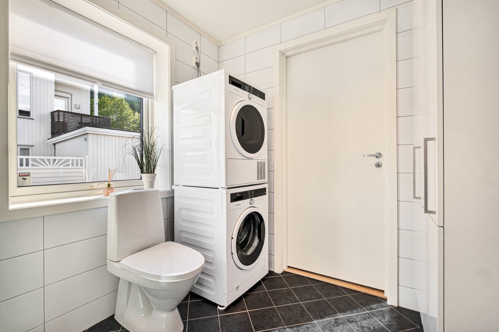 Badet har dusjkabinett og opplegg for vaskemaskin og tørketrommel. Galleribilde