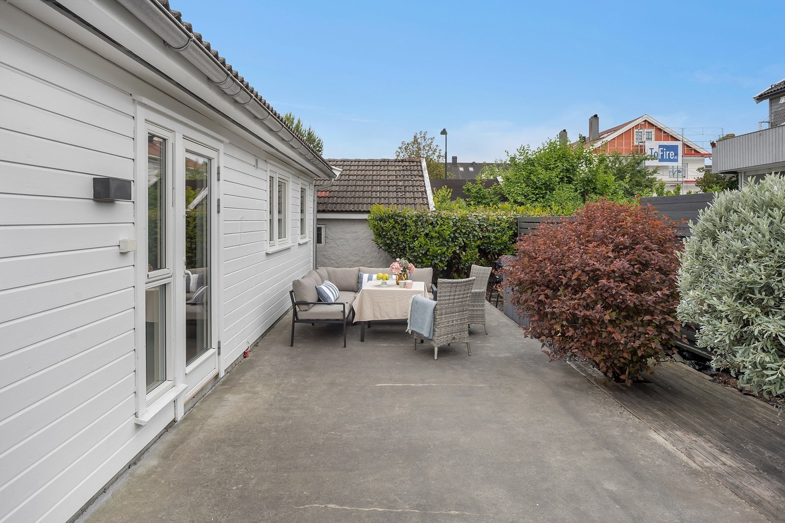 Uteplassen er delvis skjermet av hekk og levegger. Galleribilde